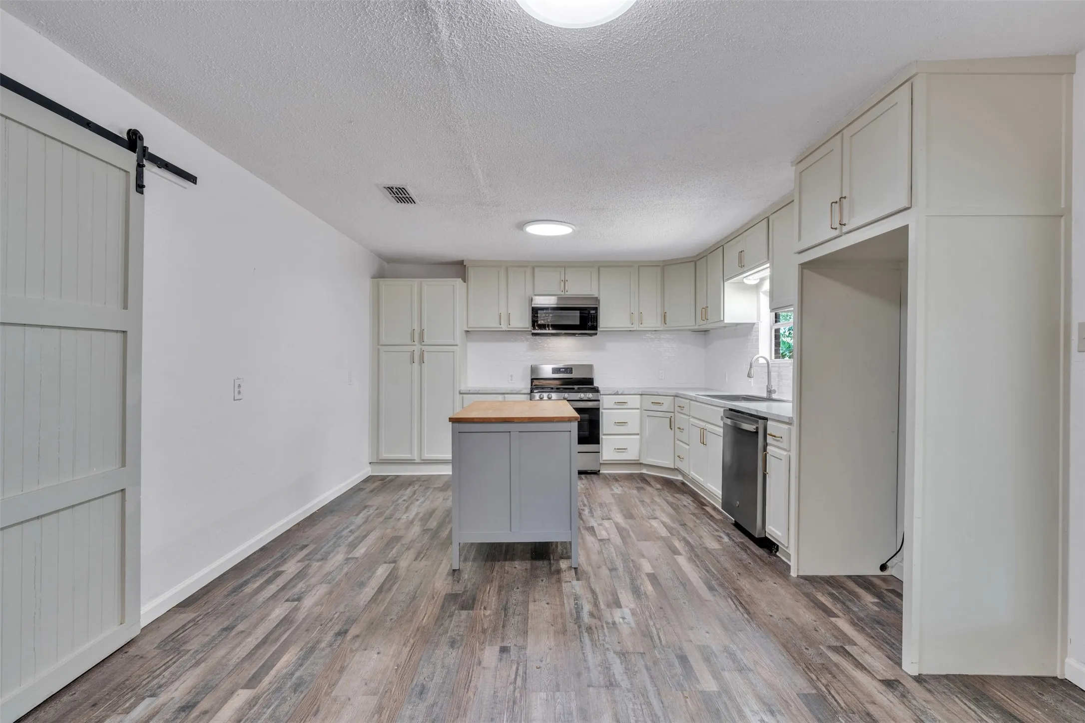 Large with room for eat in dining! Barn door leads to laundry room with overflow pantry!