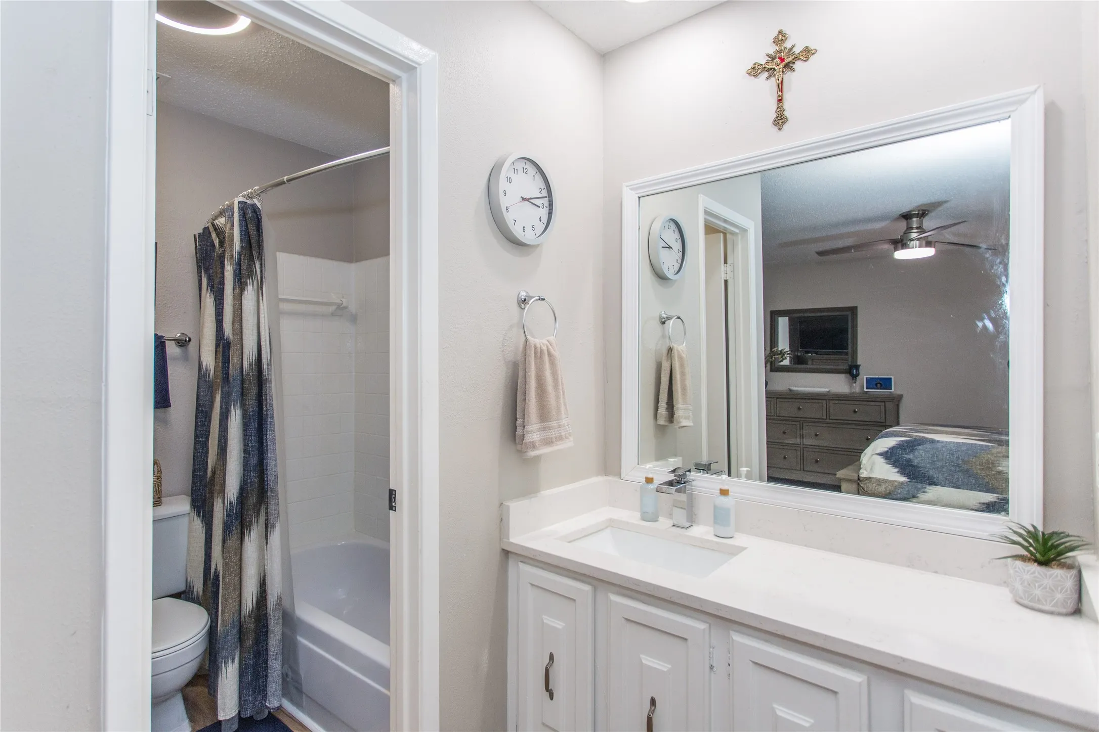 Bathroom featuring a white vanity with an integrated sink, polished chrome faucet, and white cabinetry