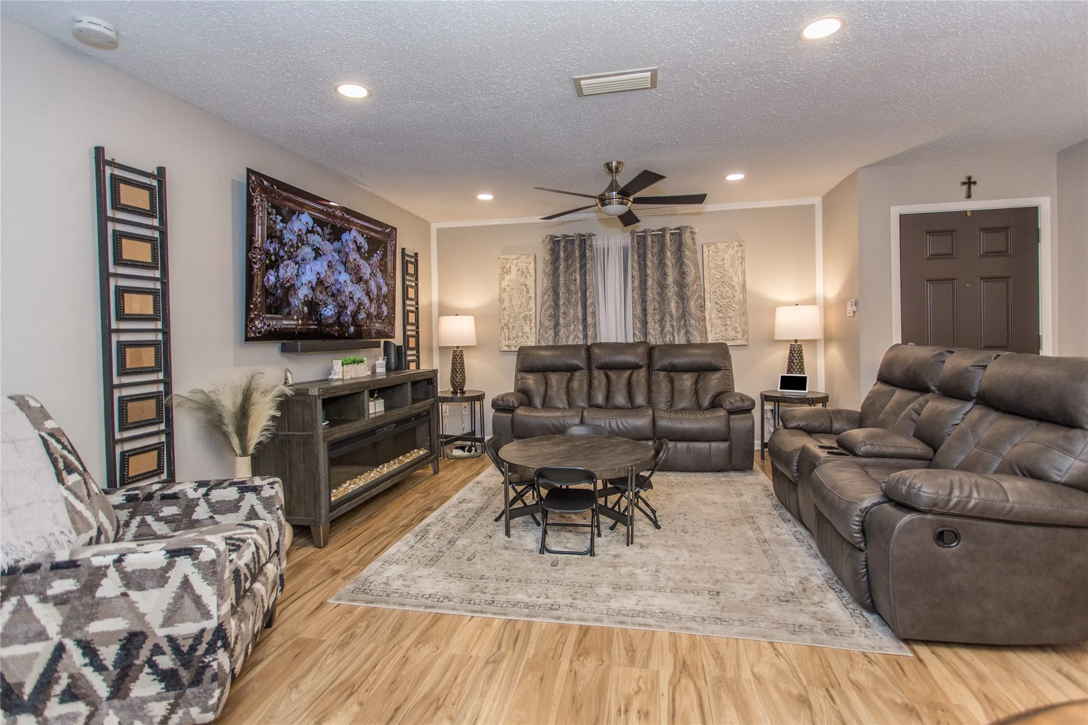 Living area featuring wood-finish flooring, recessed lighting, and a ceiling fan