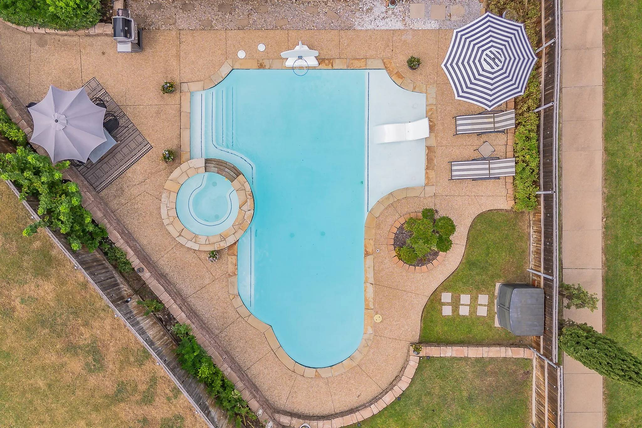 Resort-style pool with integrated spa and tanning ledge
