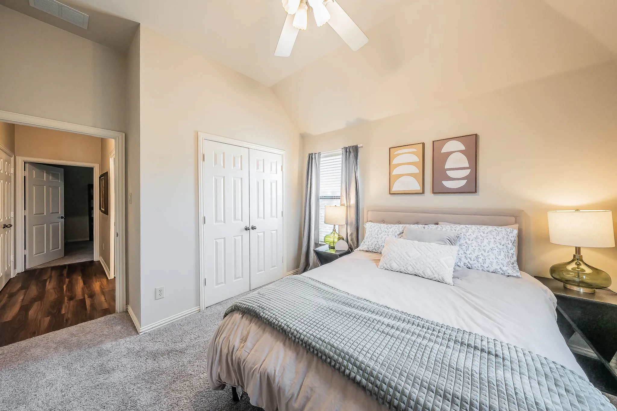 Vaulted ceiling with a ceiling fan, dual panel closet doors, window with blinds, and carpet flooring