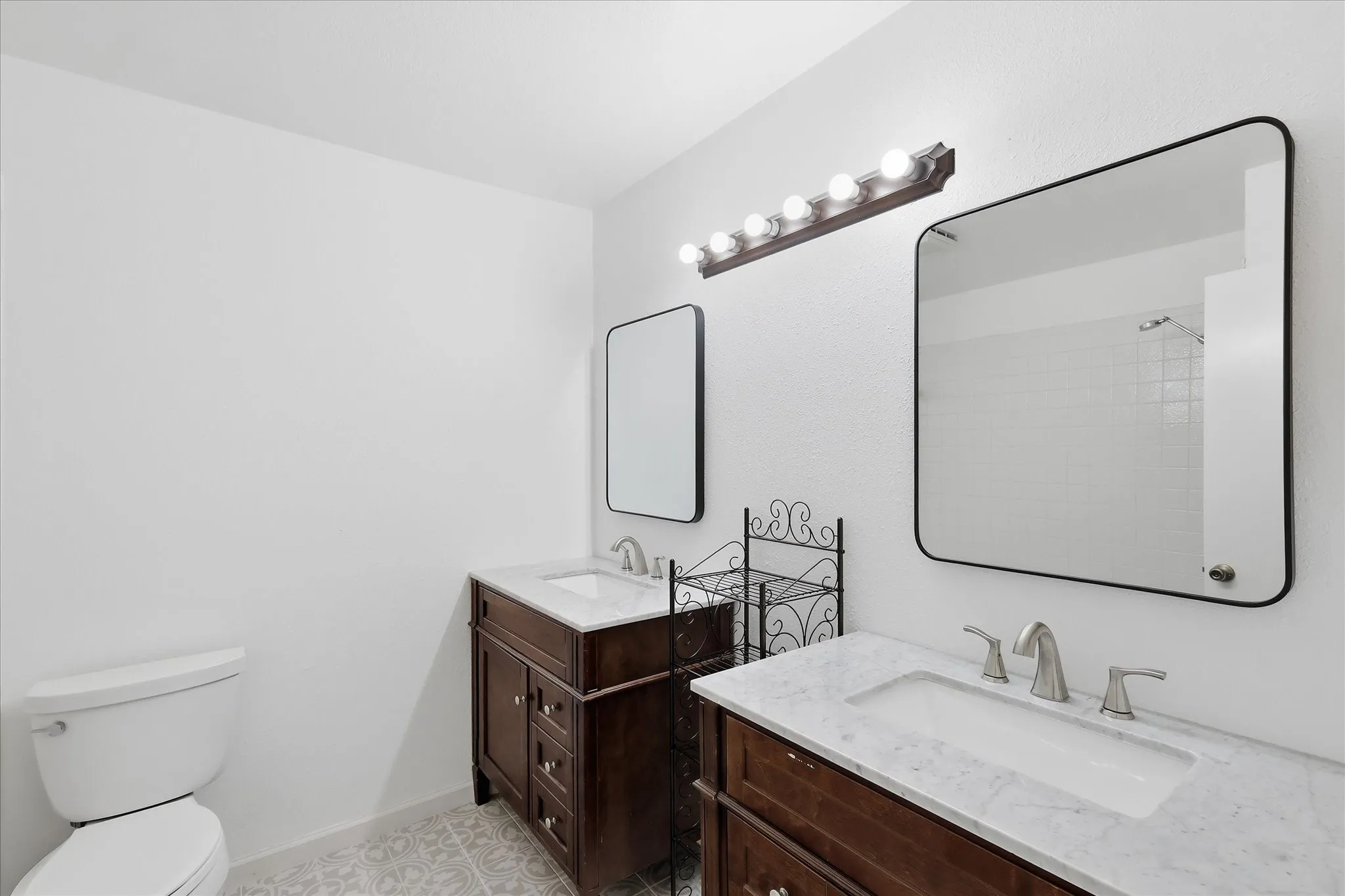 Guest bath upstairs has been renovated with new tile flooring, dual vanities, designer mirrors and more.