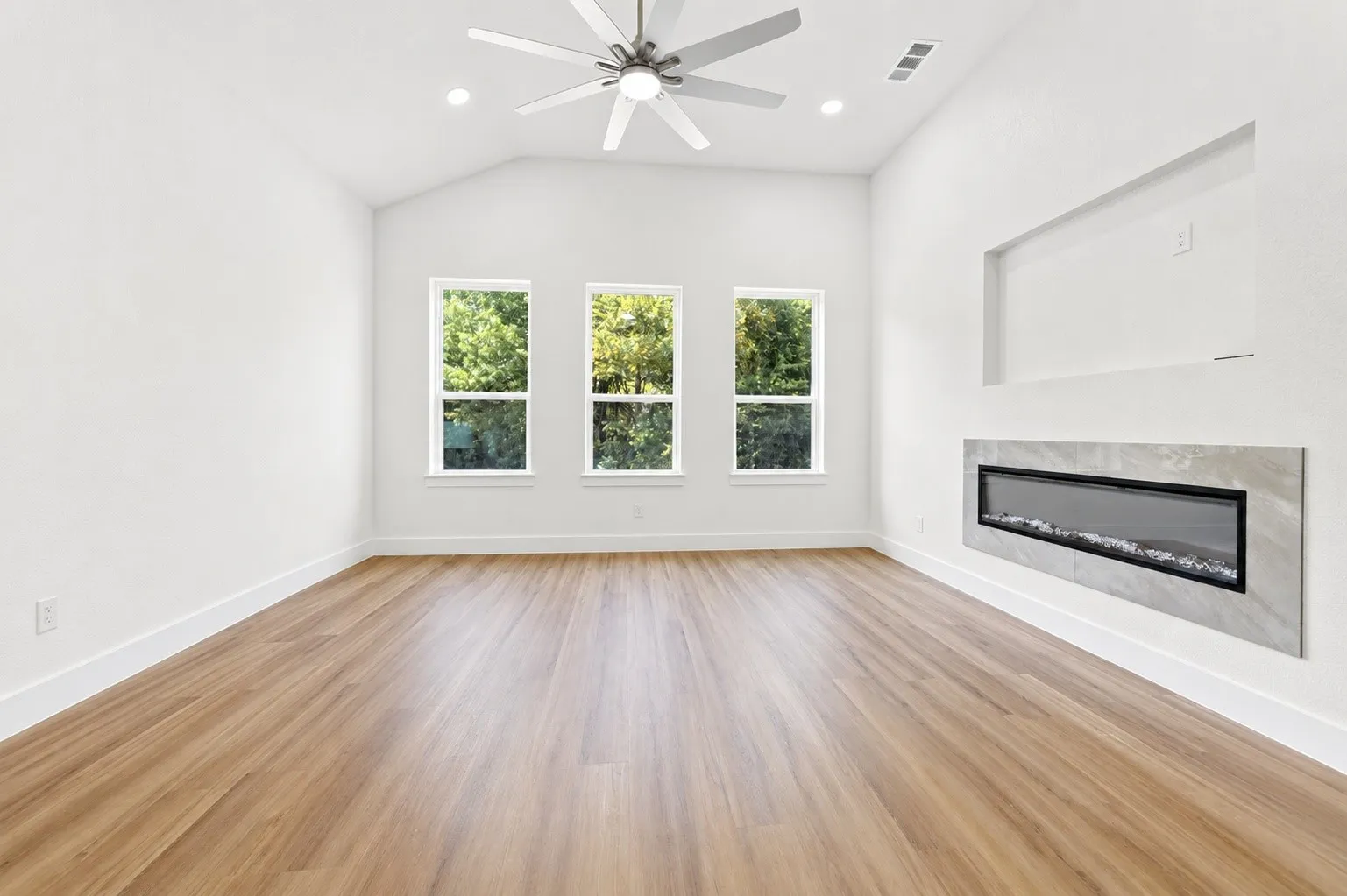 Vaulted ceiling featuring a ceiling fan, recessed lighting, and wood-finish flooring