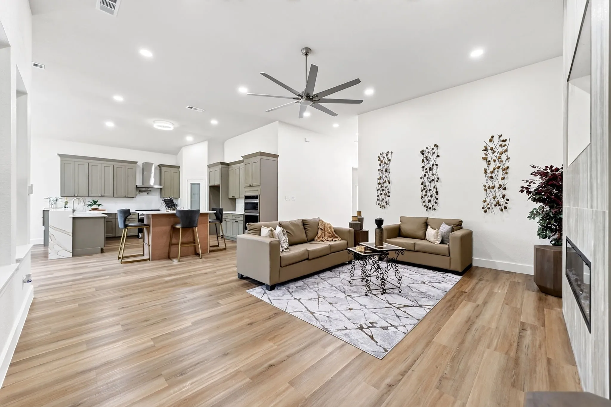 Open-concept living space featuring wood-finish flooring, recessed lighting, and a ceiling fan