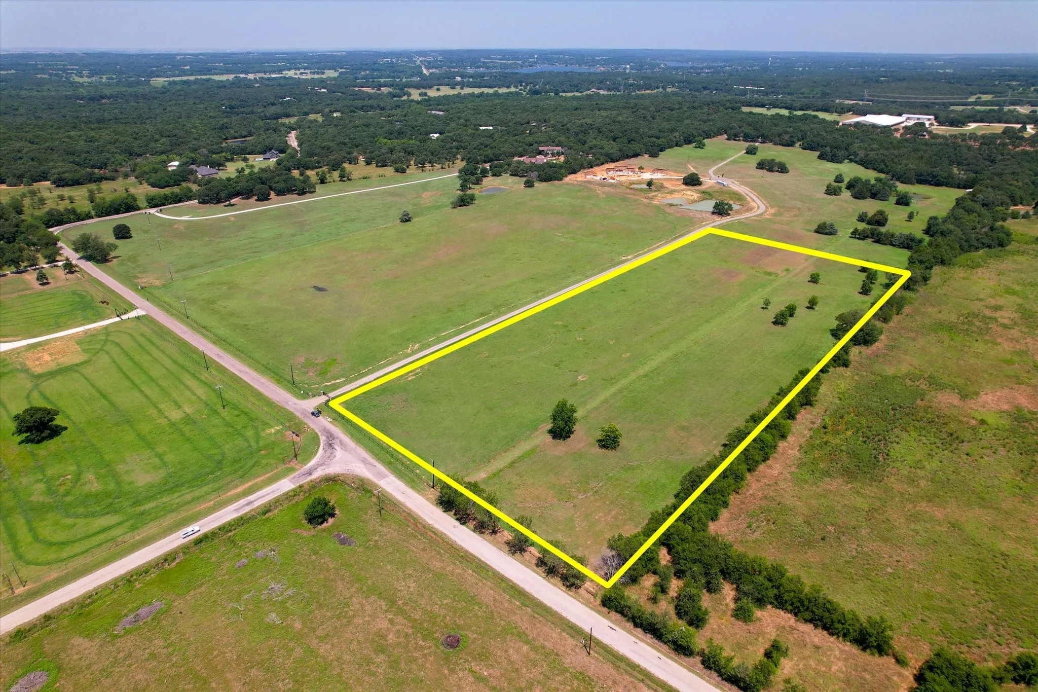 Expansive pasture offering approximately 40+ acres of cleared, gently rolling terrain with scattered mature trees and established fencing