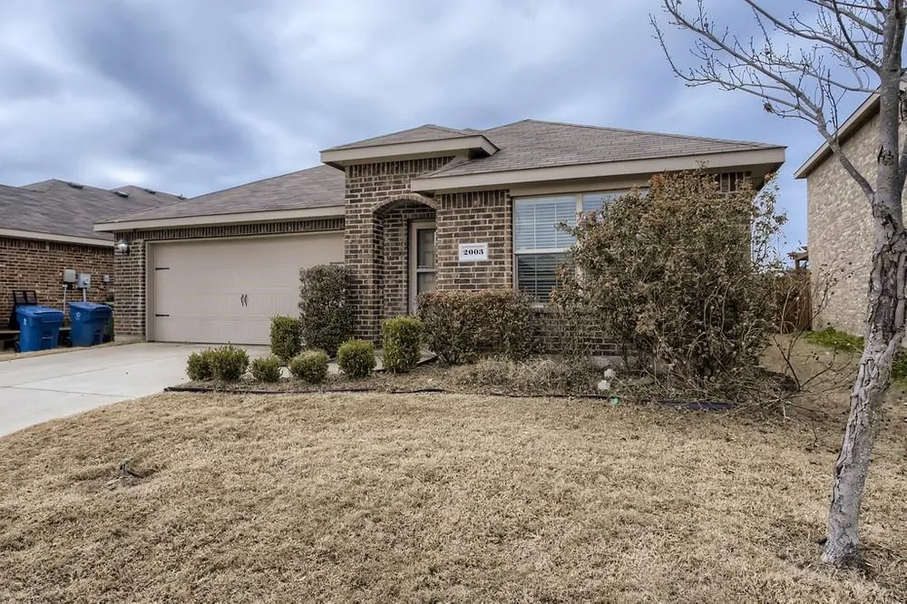 Brick-veneer exterior with a covered entry, an attached garage, and a landscaped front yard