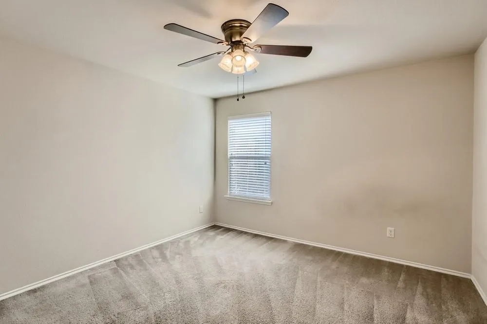 Wall-to-wall carpeting and a ceiling fan with integrated lighting