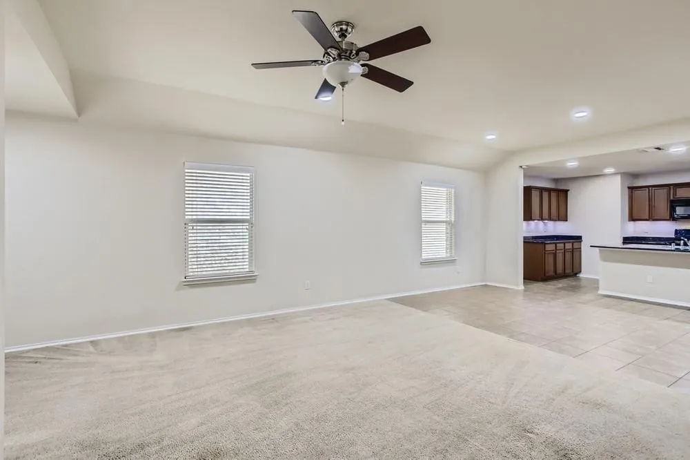 Recessed lighting throughout, vaulted ceiling, ceiling fan, carpet flooring, and tile flooring
