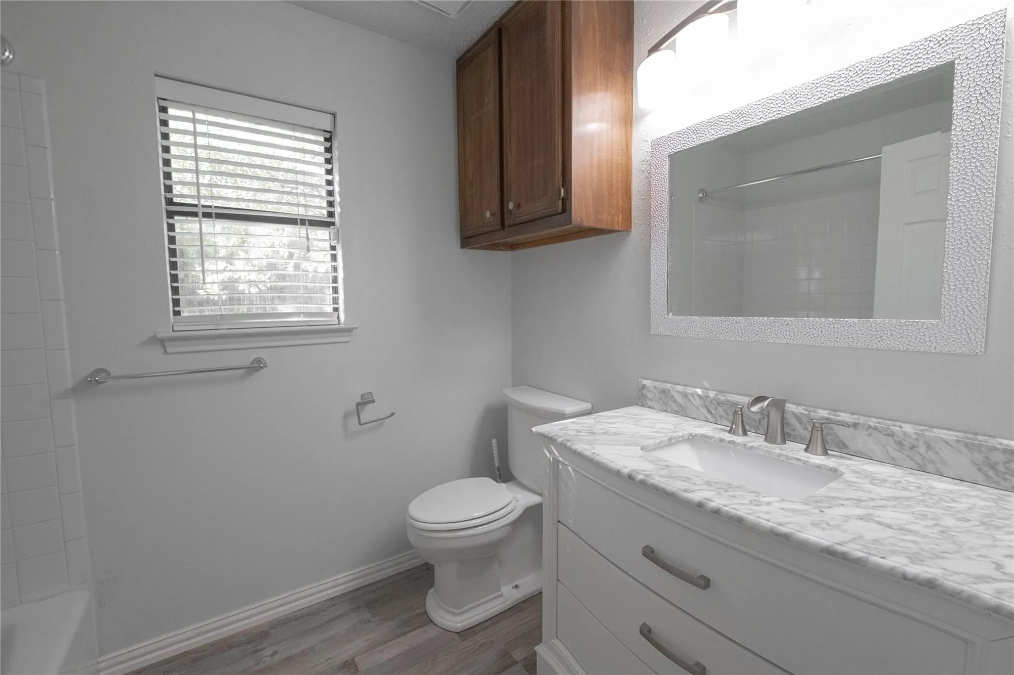 Bathroom featuring a white vanity with a stone countertop, an undermount sink, and brushed nickel fixtures