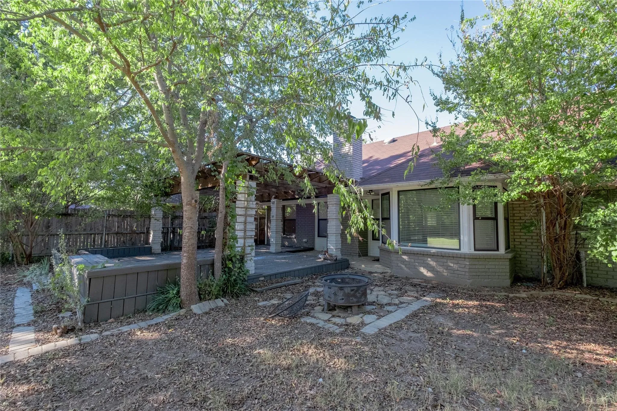 Expansive patio space with a pergola, brick columns, and a stone-paver walkway