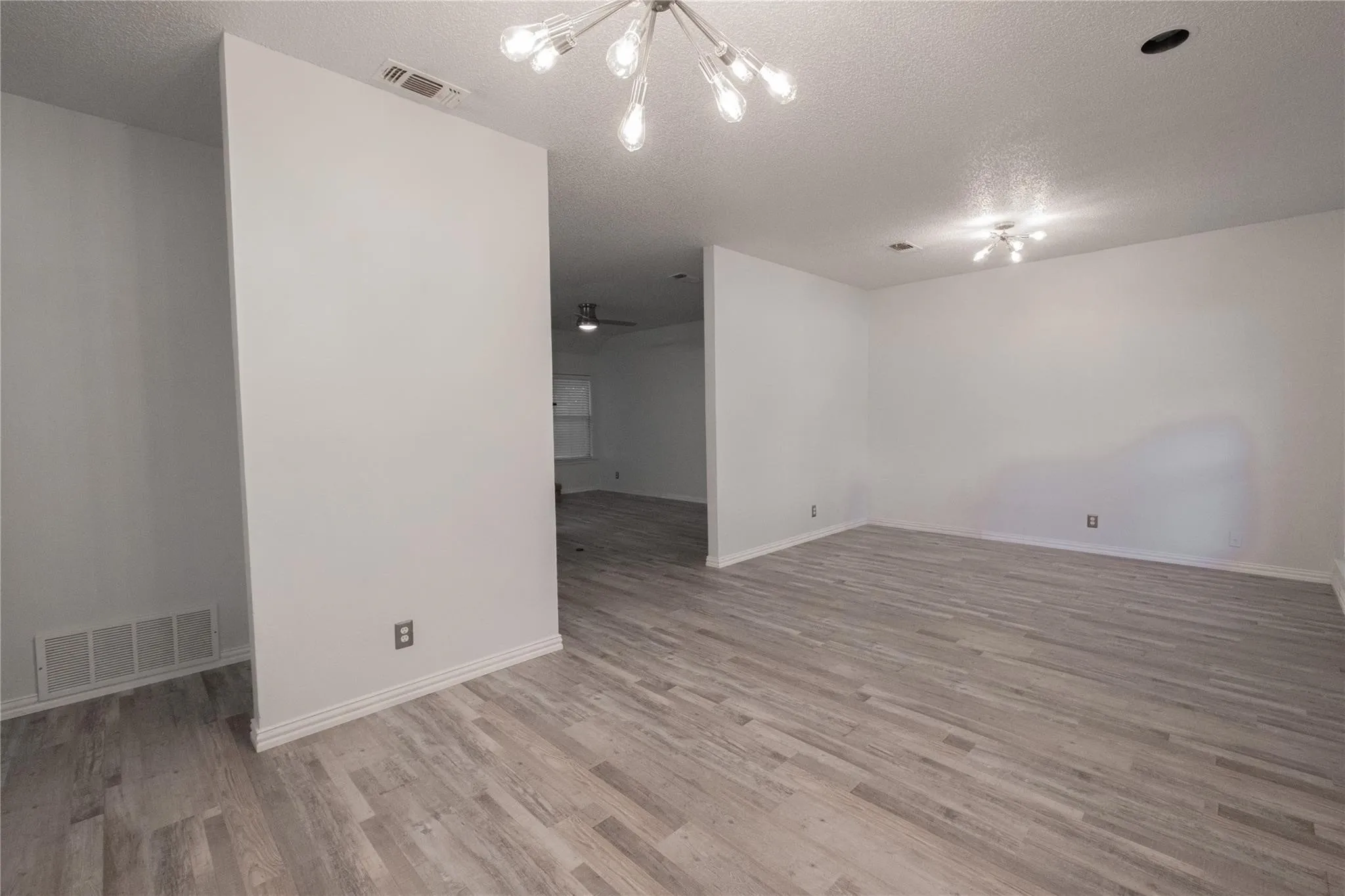 Wood-finish flooring throughout, white walls, and contemporary ceiling light fixtures