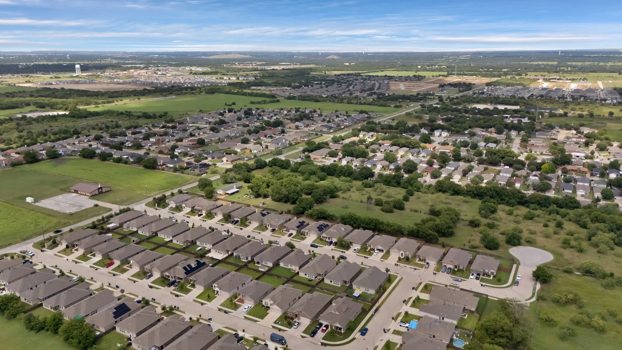 Aerial view of property and surrounding area with nearby suburban area