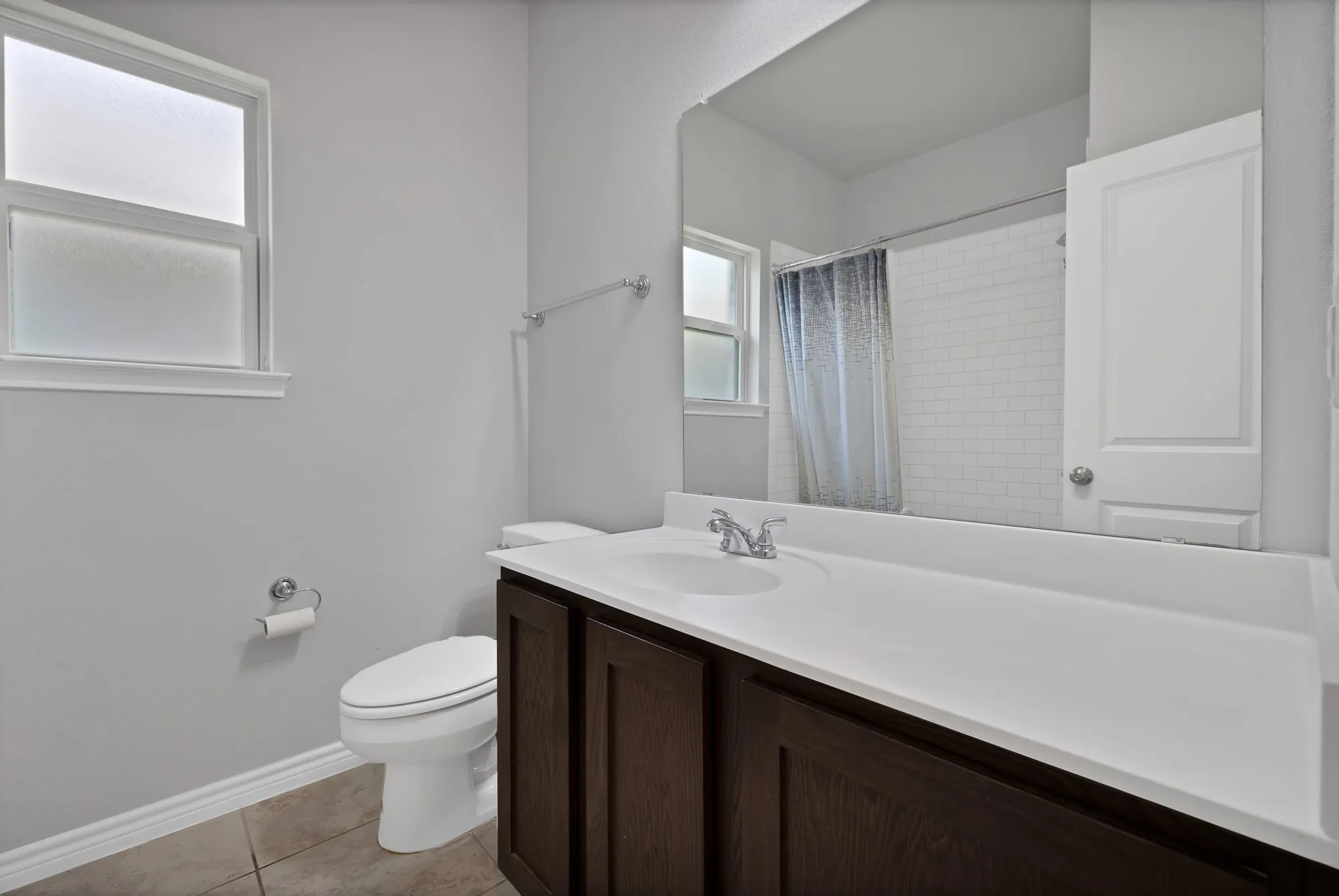 Bathroom with vanity, tile patterned floors, and a shower with shower curtain