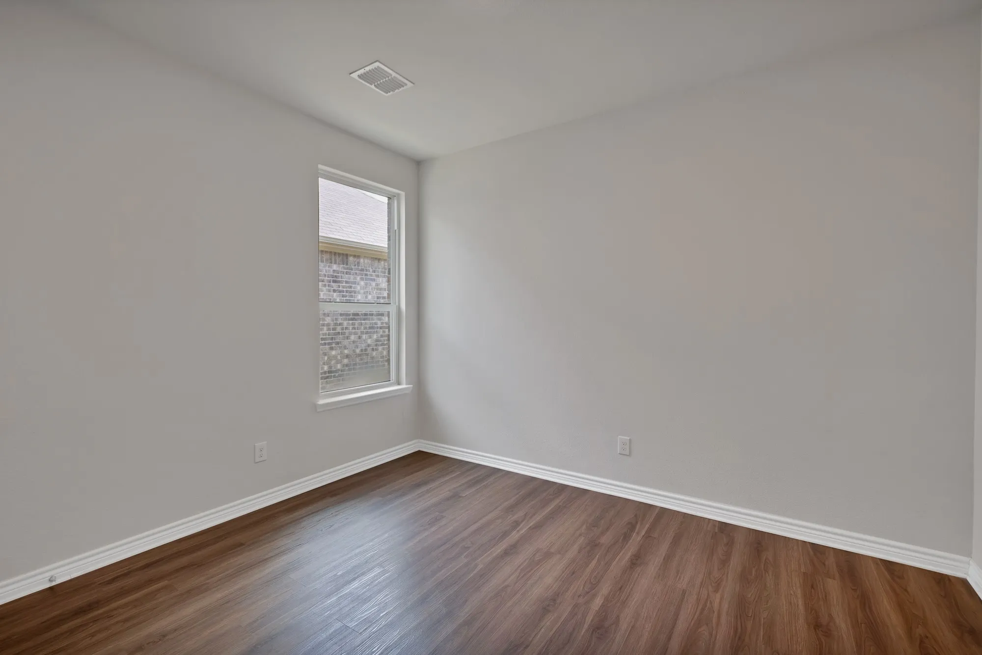 Unfurnished room with dark wood-type flooring and baseboards