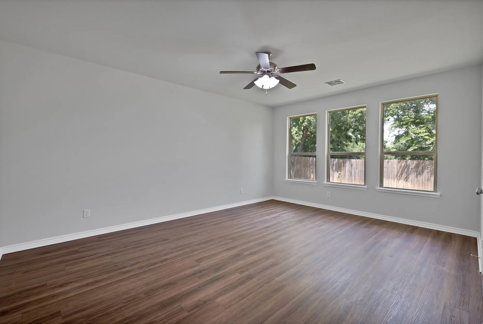 Spare room with a ceiling fan and dark wood-type flooring