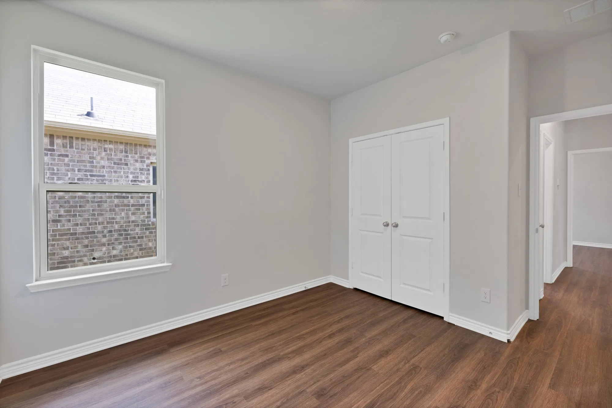 Unfurnished bedroom with dark wood-style floors and a closet