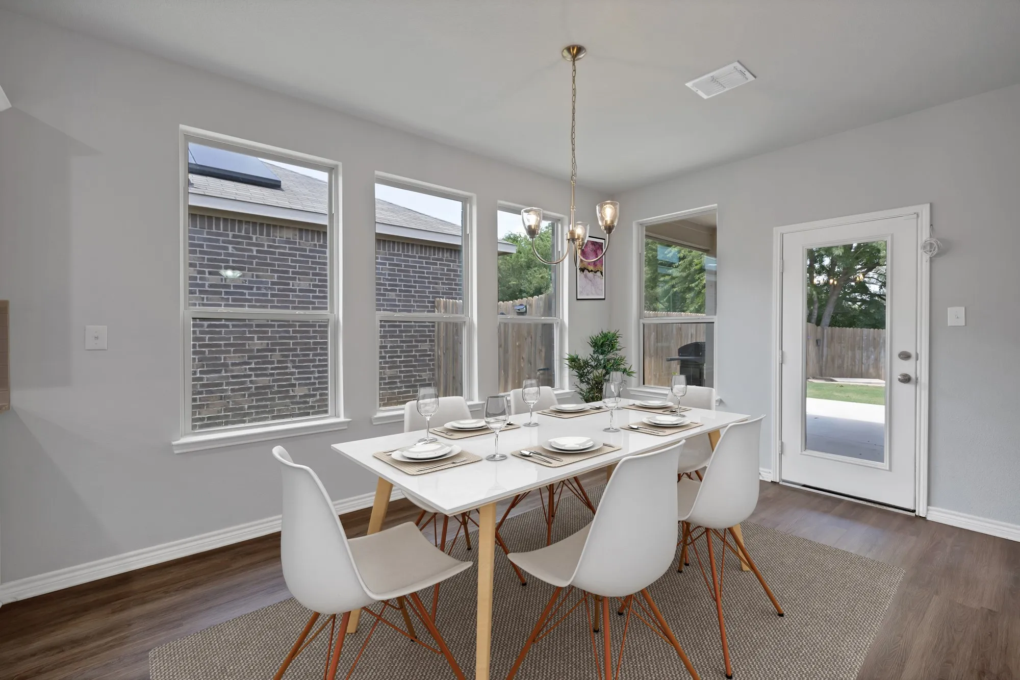 Dining area featuring dark wood-style flooring, plenty of natural light, and a chandelier