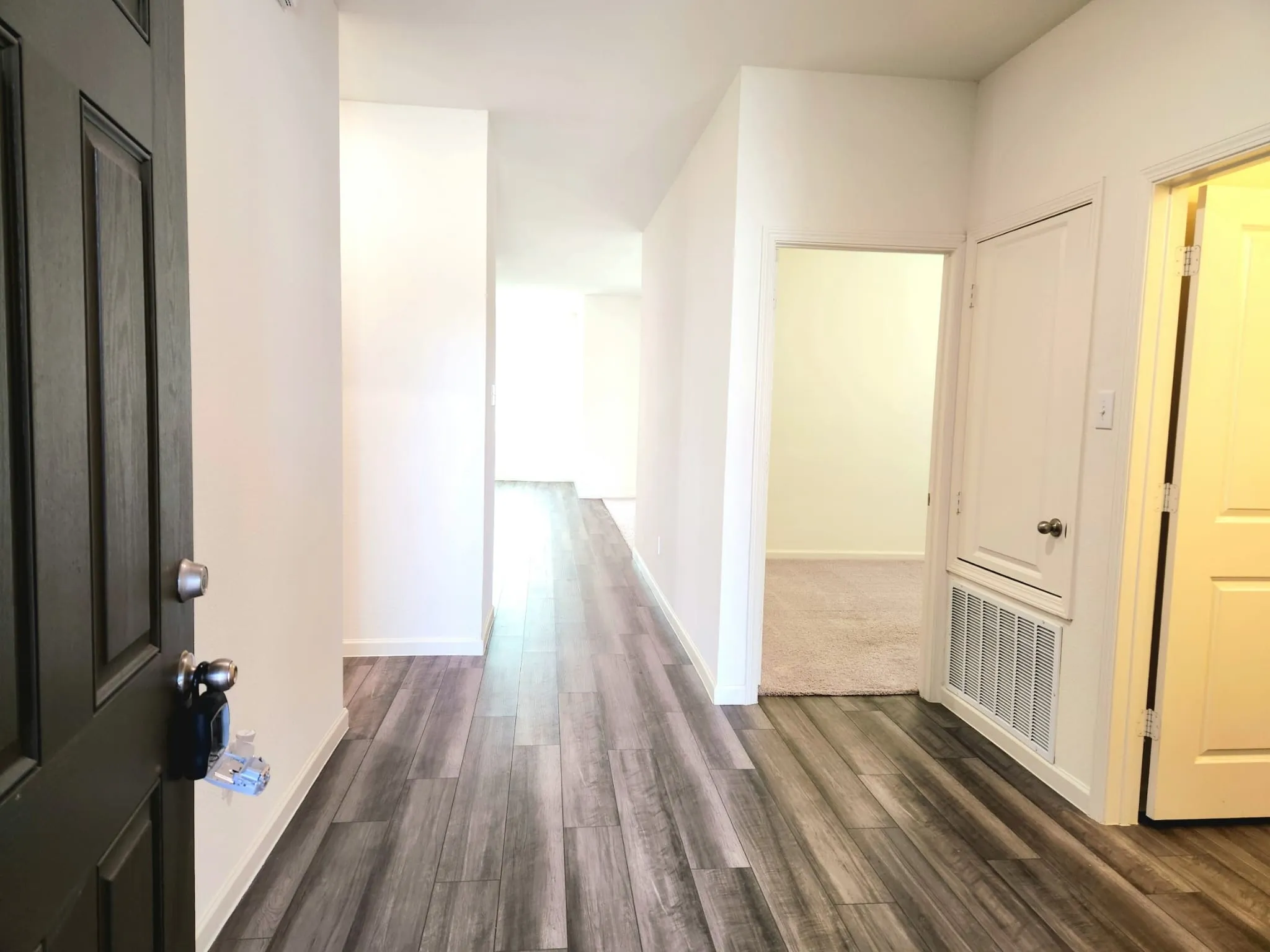 Wood-finish flooring throughout the main corridor leading to additional spaces