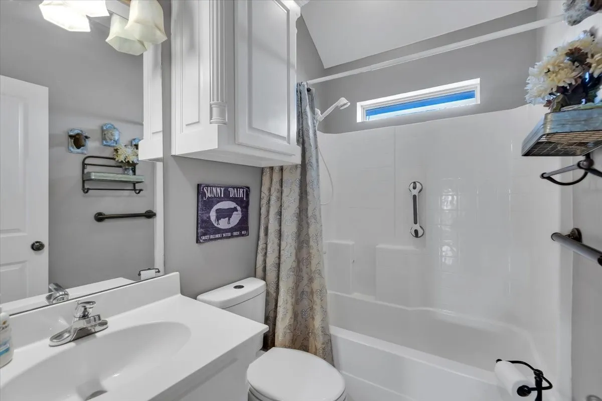 White vanity with integrated sink, chrome faucet, and mirrored medicine cabinet