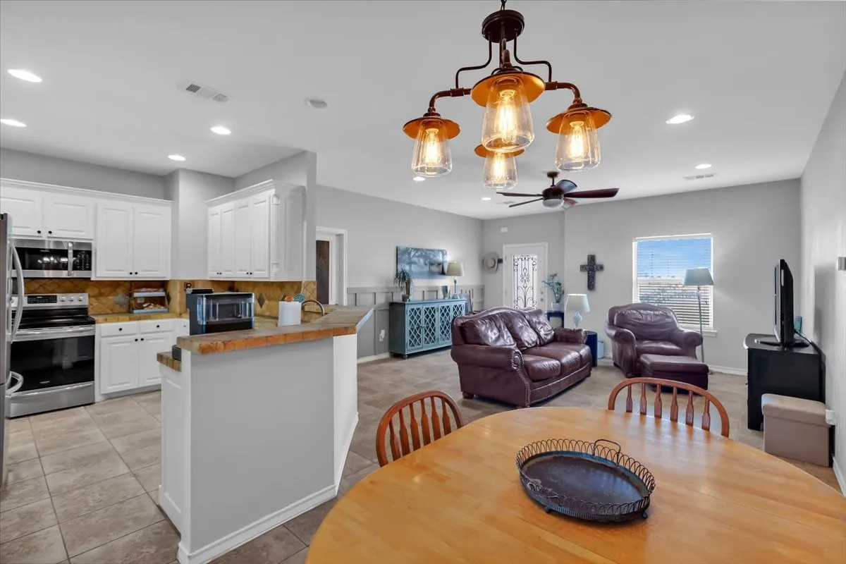 Kitchen with white cabinetry, stainless steel appliances, and a tiled backsplash