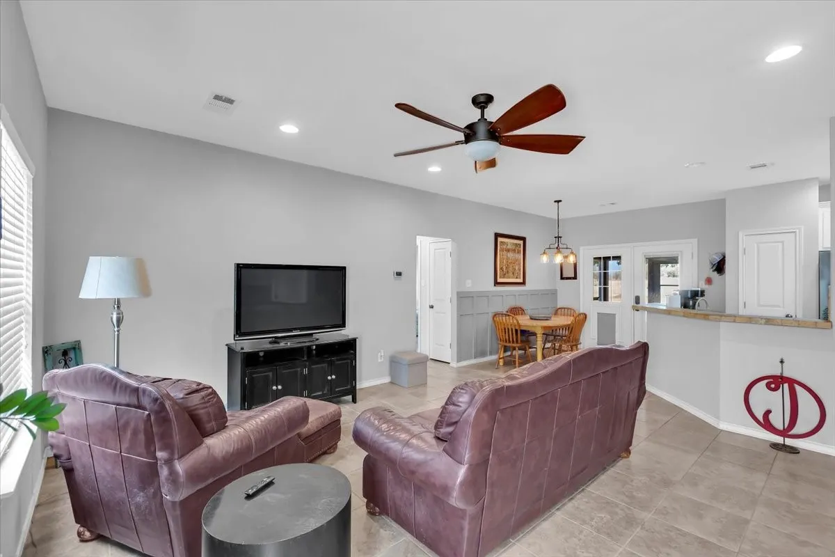 Vaulted ceilings with recessed lighting, ceiling fan, and tile flooring