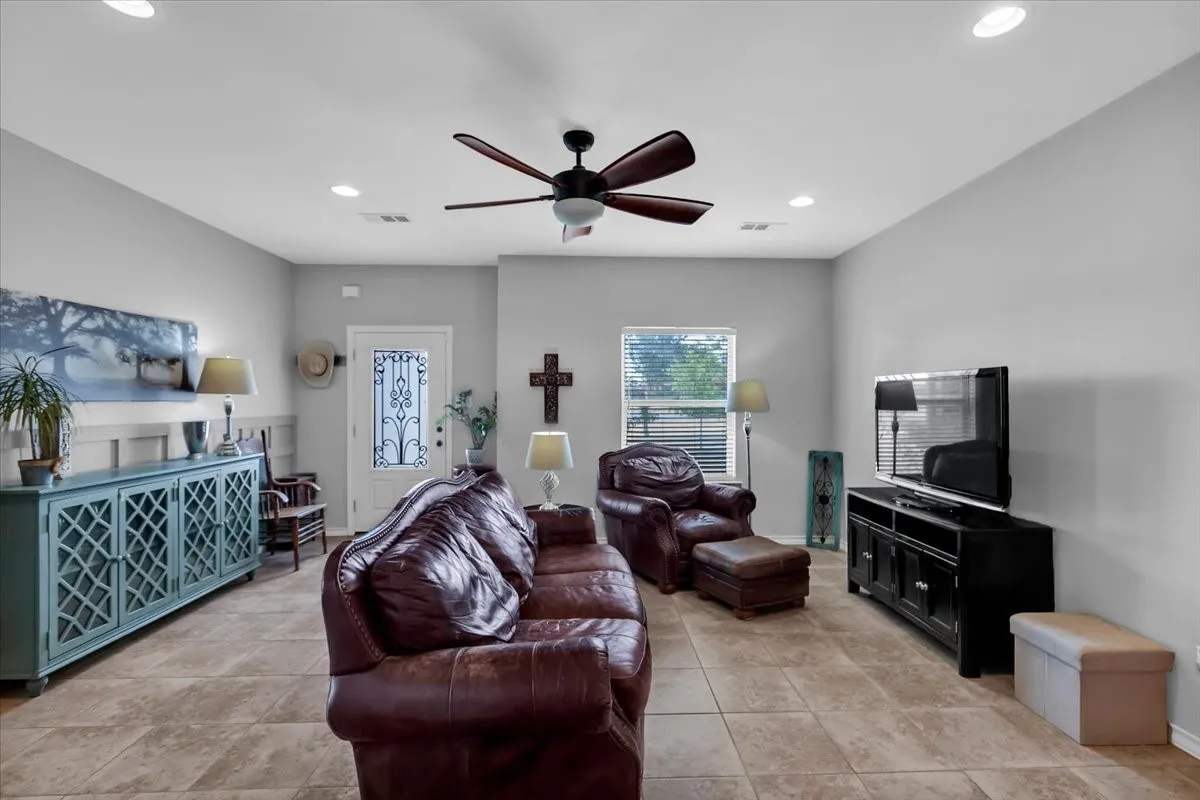 Recessed lighting throughout, tile flooring, a ceiling fan with light fixture, and a window with blinds
