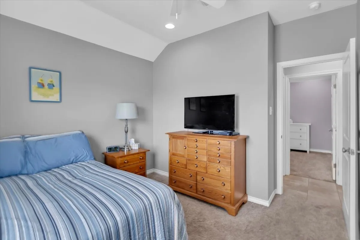 Vaulted ceiling, recessed lighting, neutral wall tones, carpet flooring, interior doorway