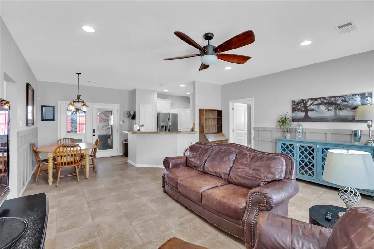 Open-concept living area with tile flooring, recessed lighting, and a ceiling fan