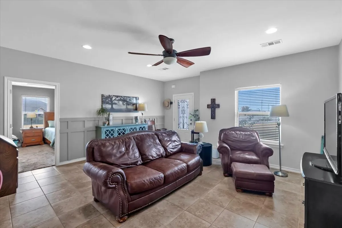 Tile flooring, recessed lighting, ceiling fan, board and batten wall detailing, and a window with blinds