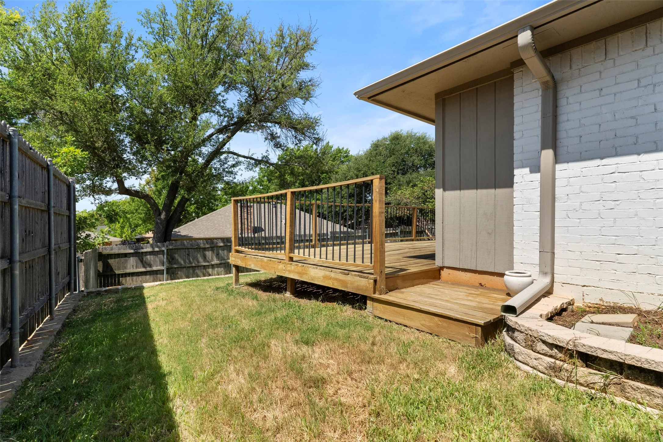 Wood deck featuring black metal balusters and wood handrails