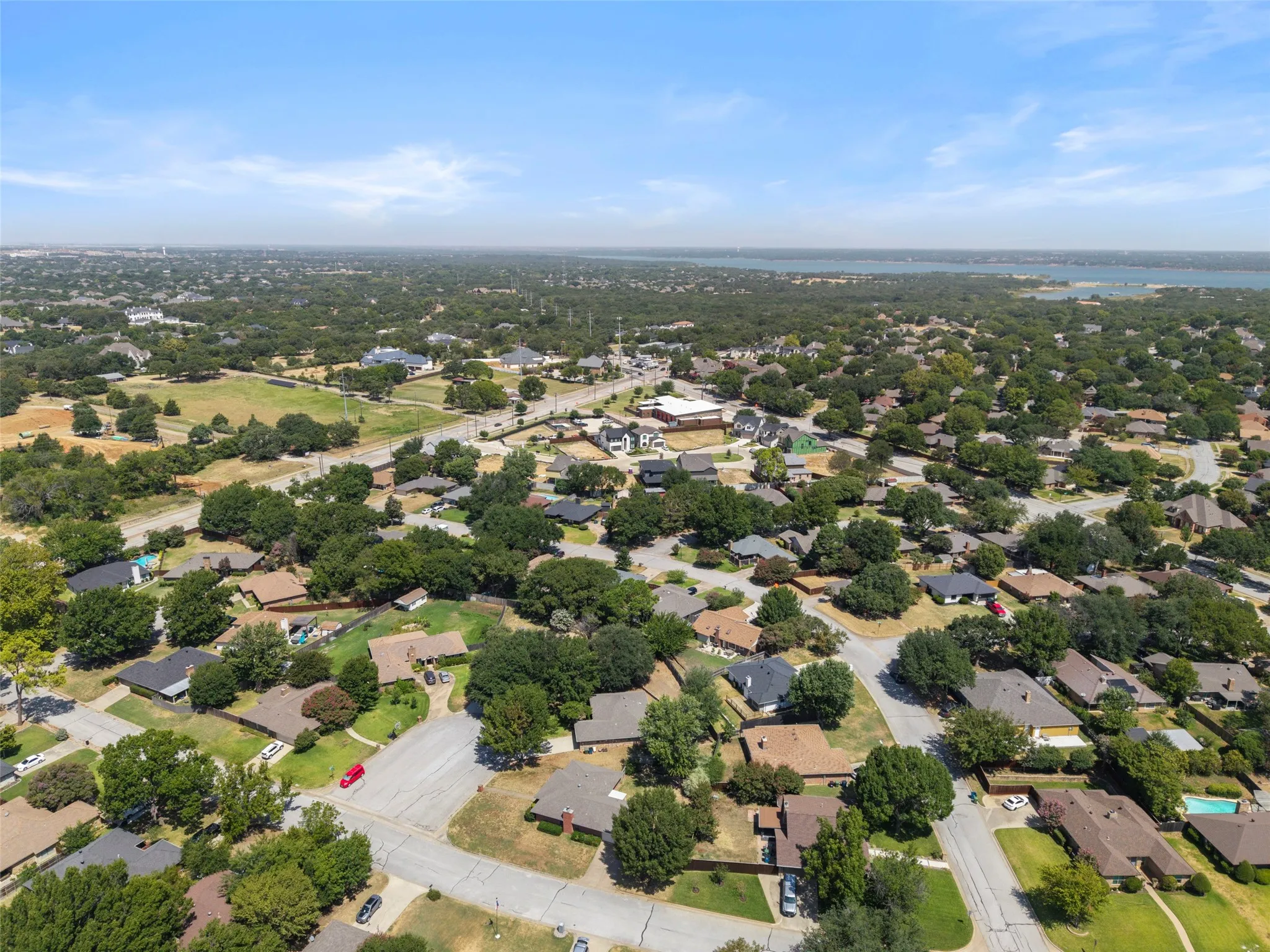 Expansive residential area featuring numerous mature trees and a distant body of water