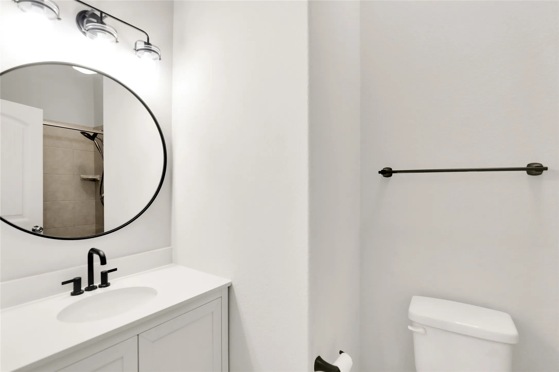 White vanity cabinet with a white countertop and an undermount sink