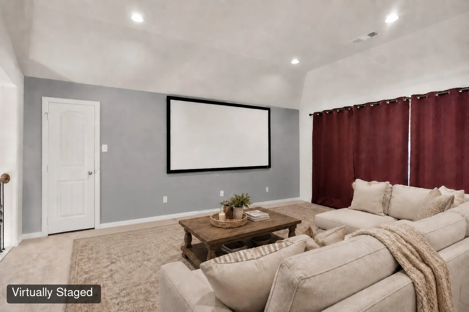 Integrated projection screen and recessed lighting in a spacious room with vaulted ceilings