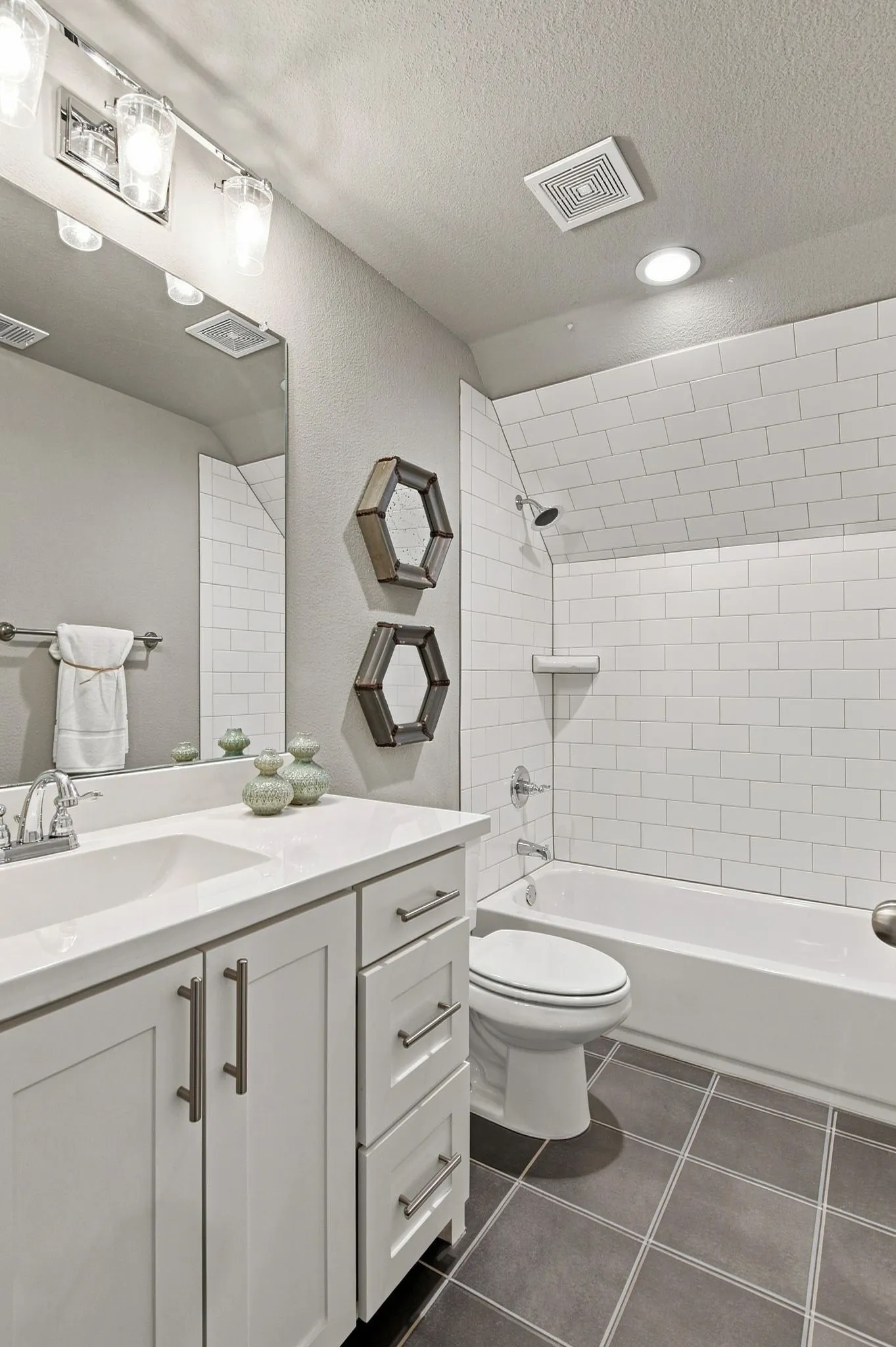 White vanity with an integrated sink, polished chrome faucet, and brushed nickel hardware
