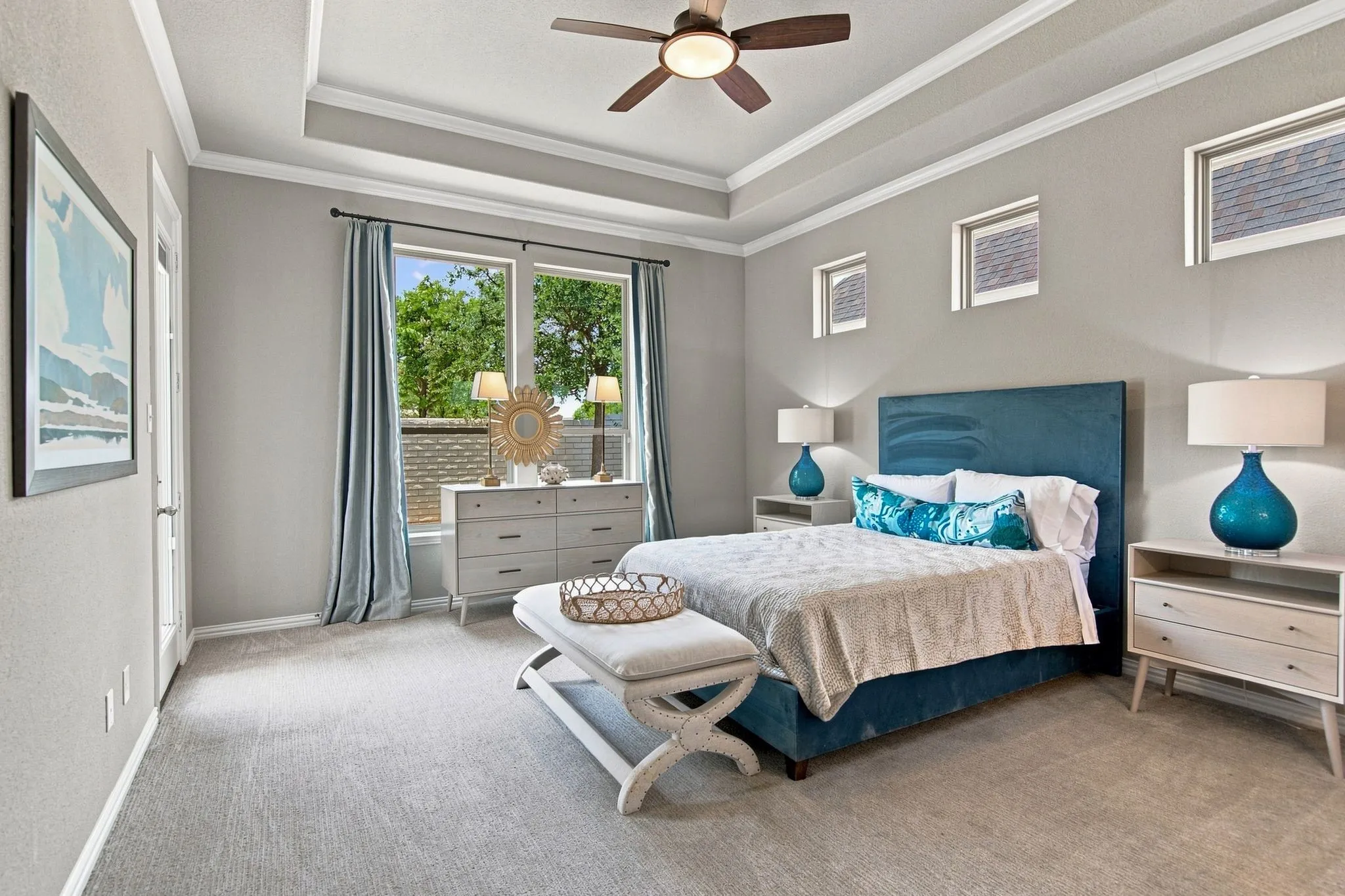 Tray ceiling with crown molding, ceiling fan, and light gray wall paint