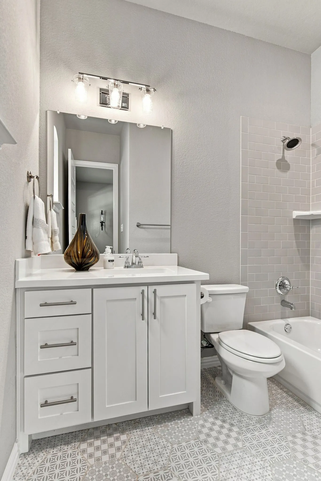 White vanity with chrome hardware, countertop, and a built-in sink