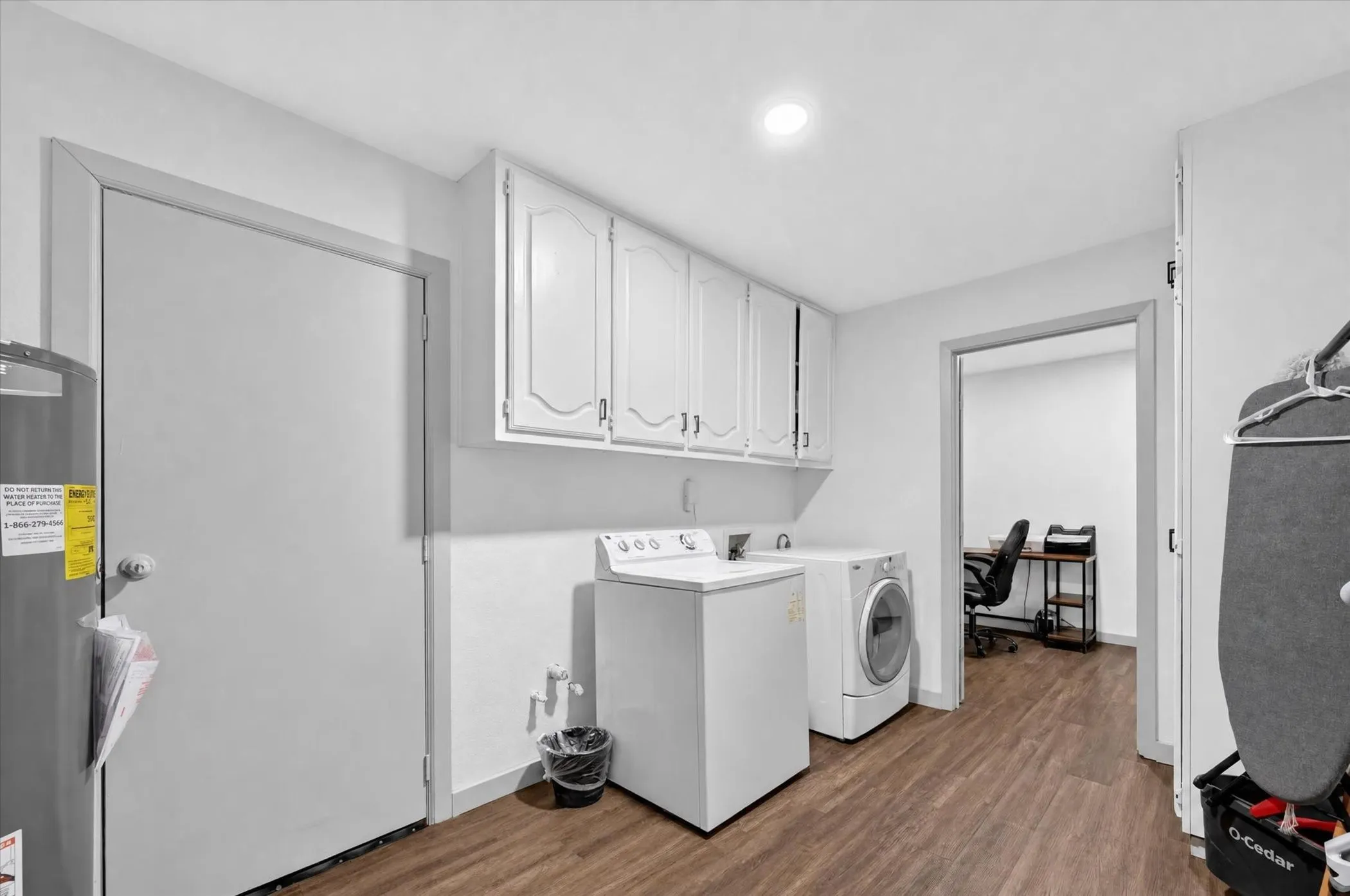 Laundry area featuring wood-finish flooring, white cabinetry, and recessed lighting