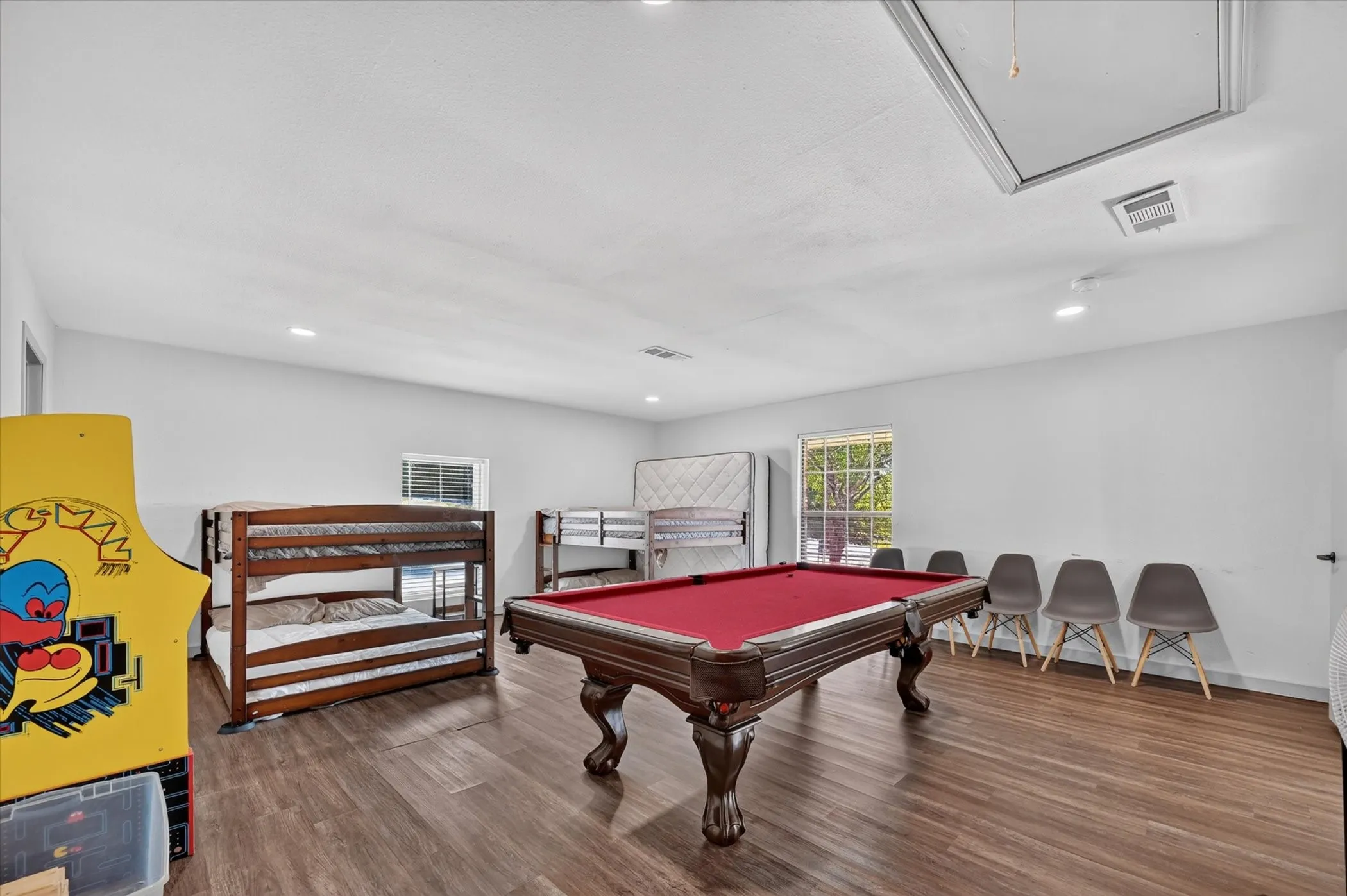 Spacious room with wood-finish flooring, recessed lighting, and a window for natural light