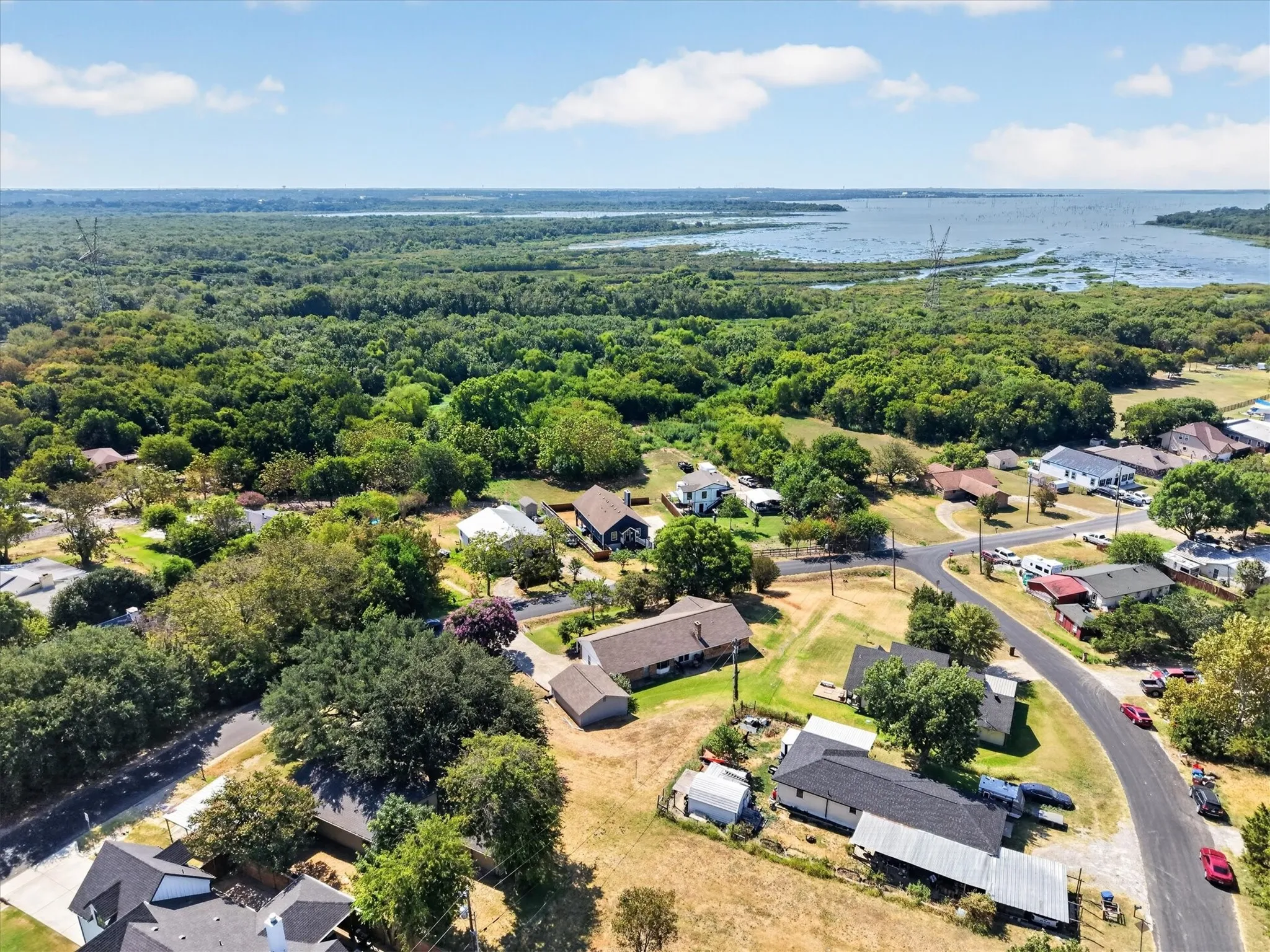 Lush green landscape featuring a prominent body of water and scattered residential properties