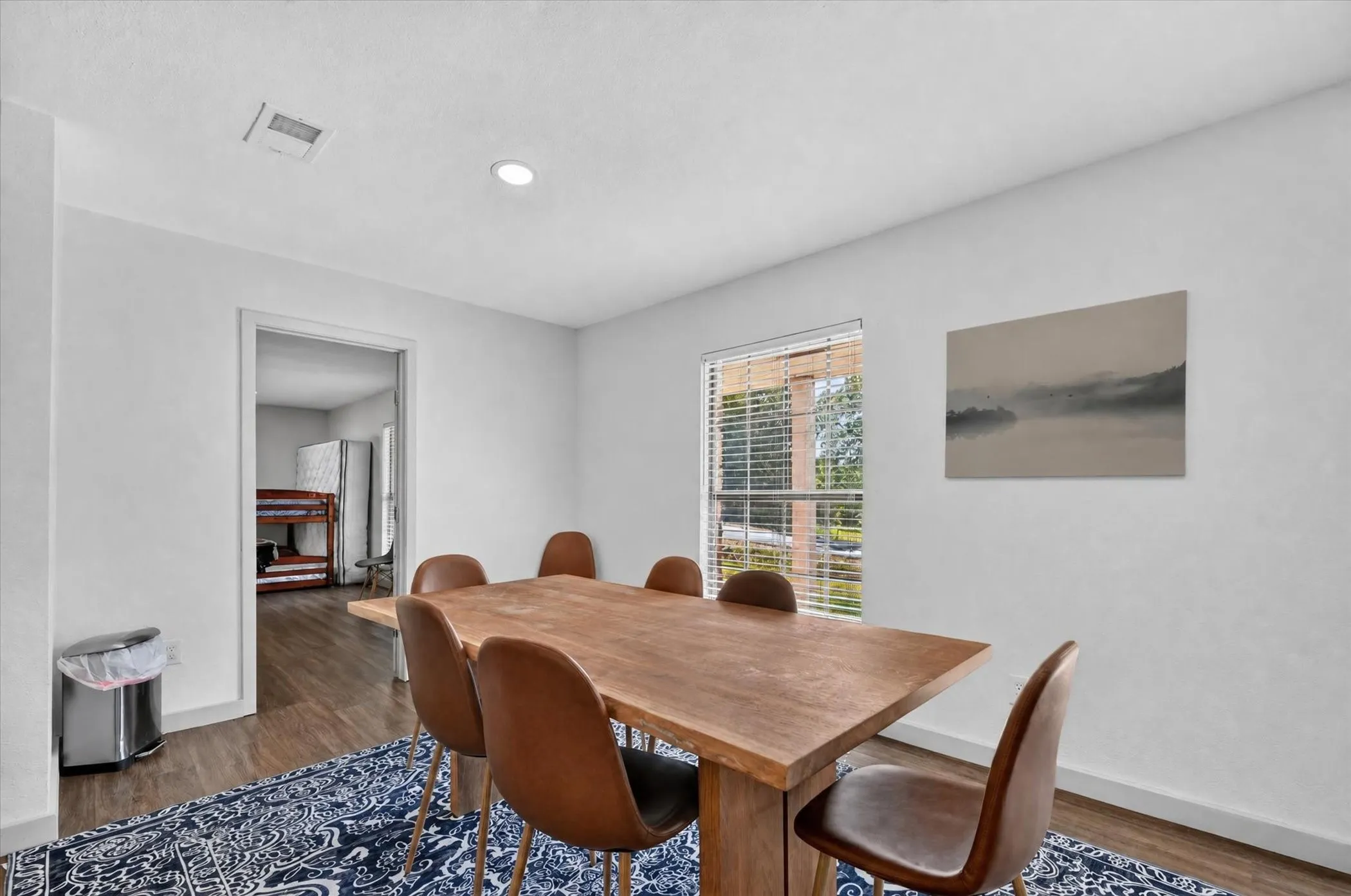 Recessed ceiling lighting, wood-finish flooring, white painted walls, and window with blinds