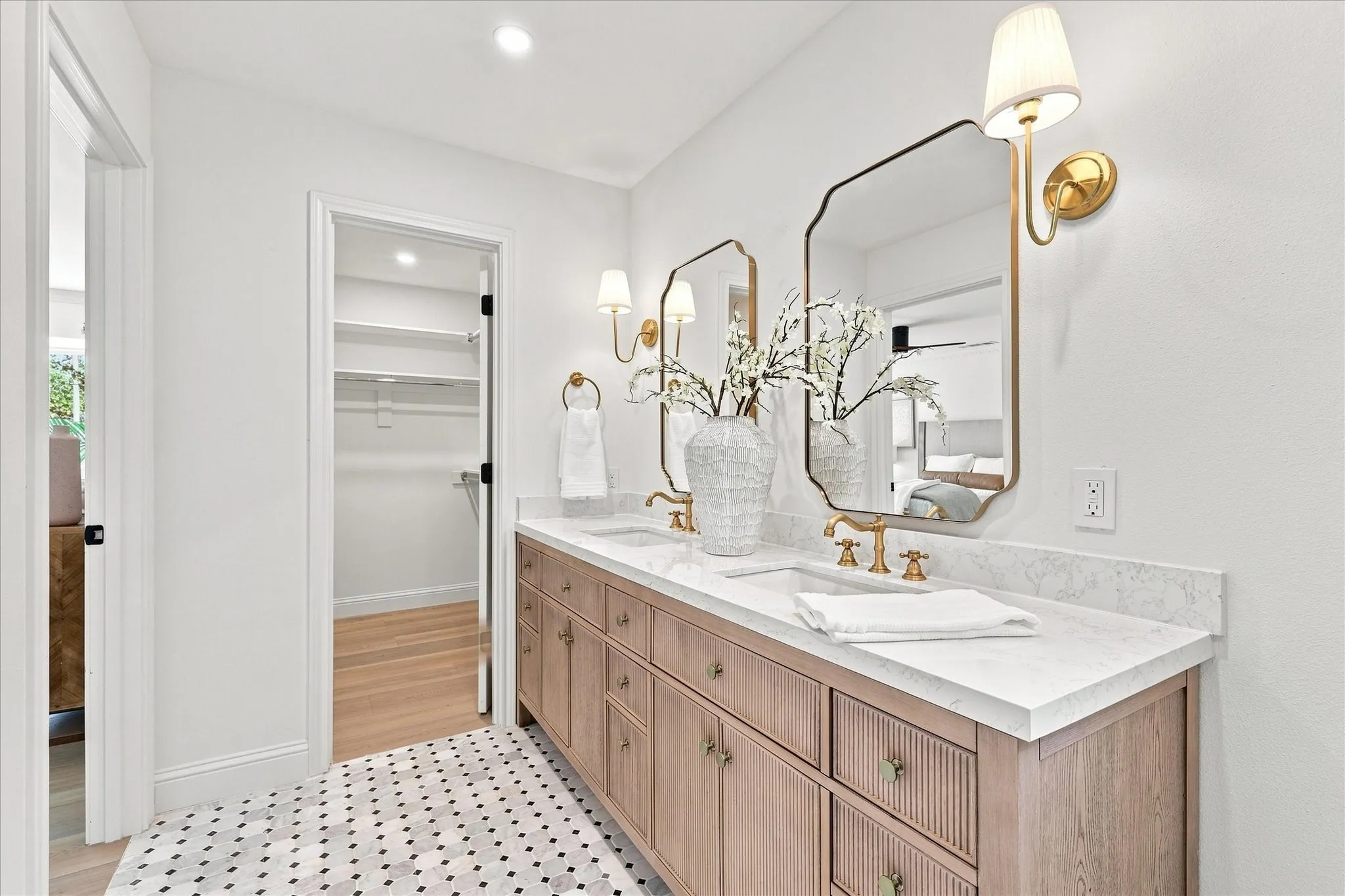 Primary bath with large walk-in closet, new custom cabintry, dual sinks with updated fixtures and lighting