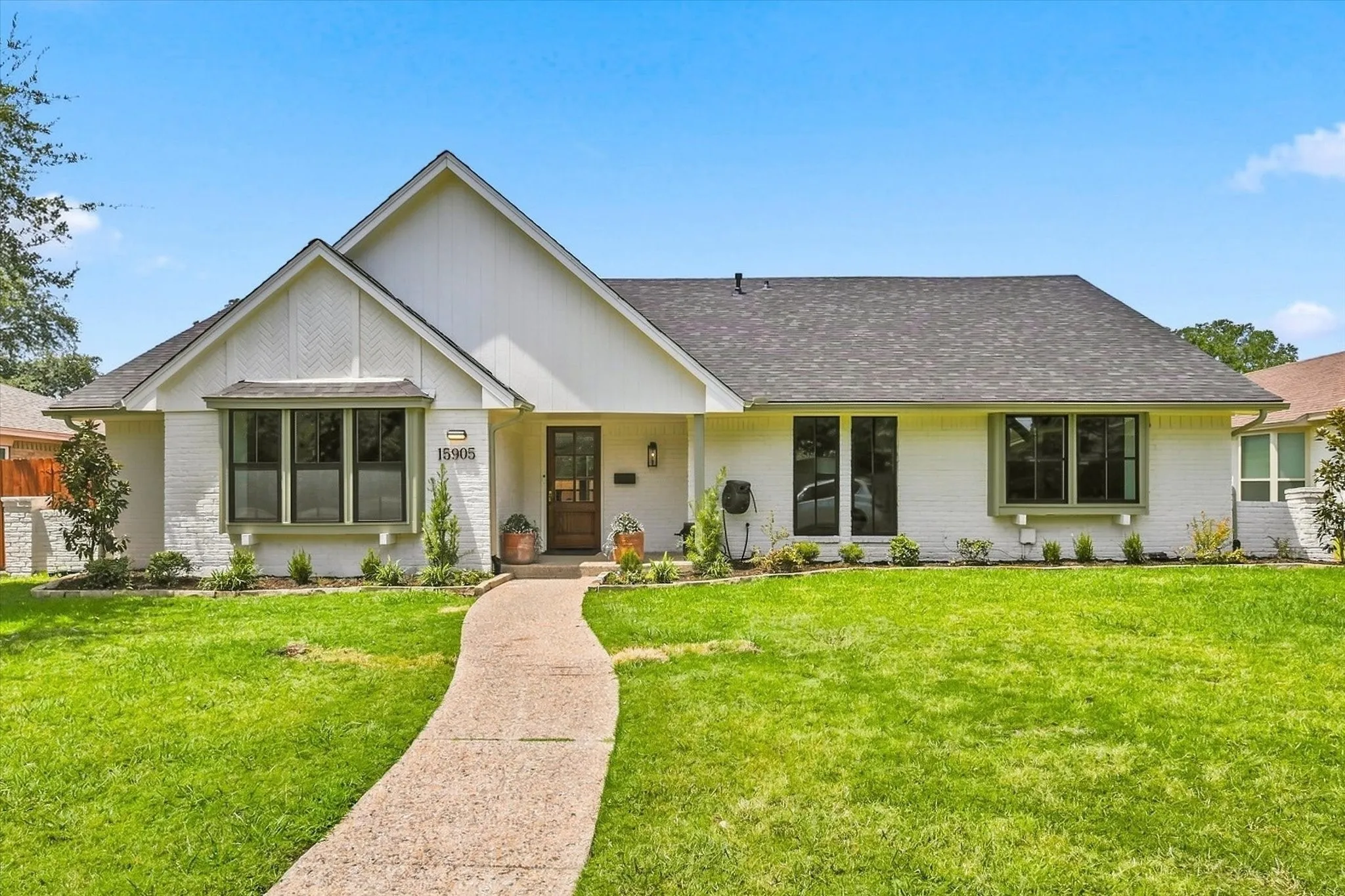 Stunning drive up appeal with white exterior, new roof, new windows and professionally landscaped