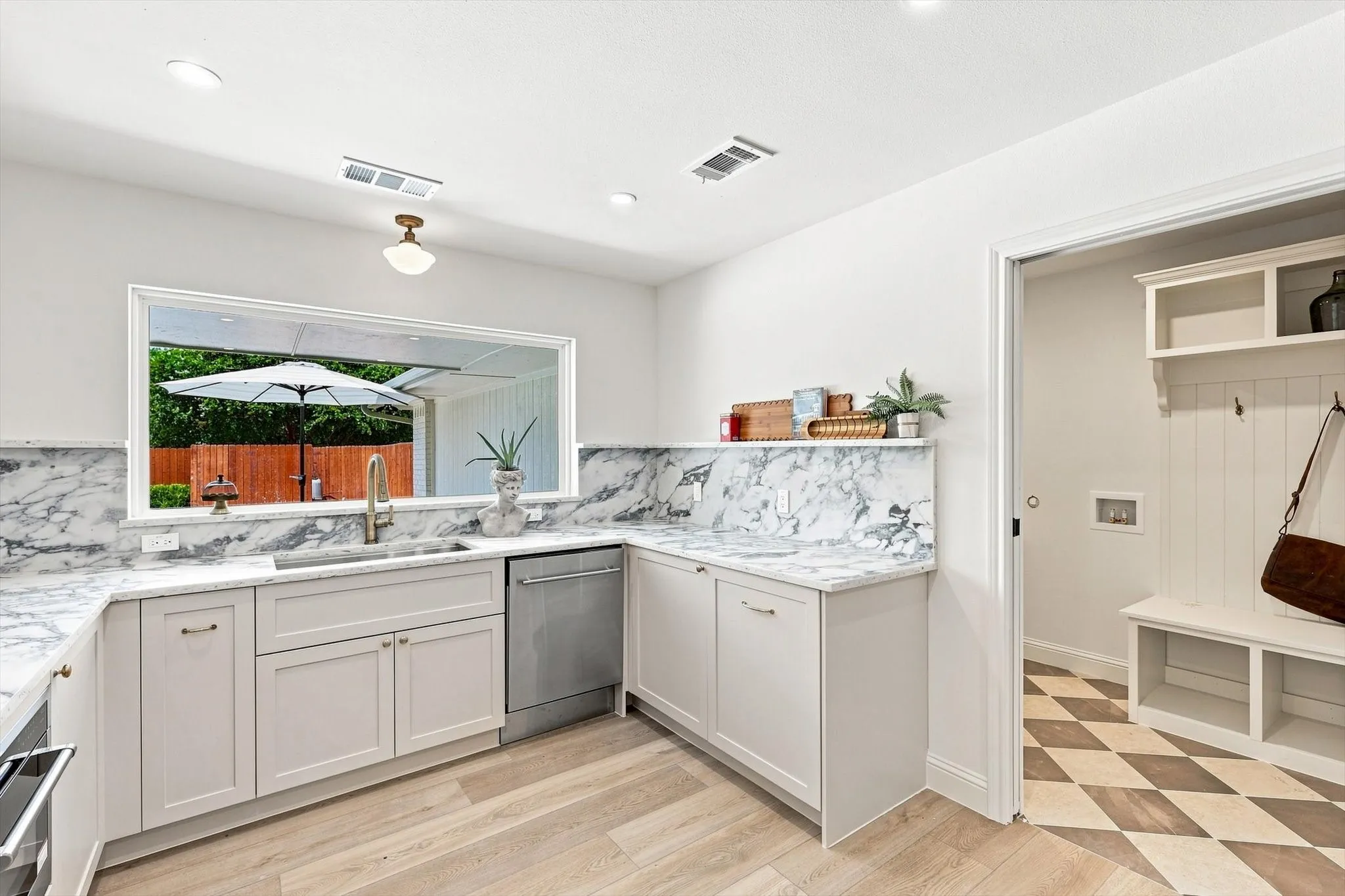 Mudroom and utility space adjacent to kitchen and garage entry