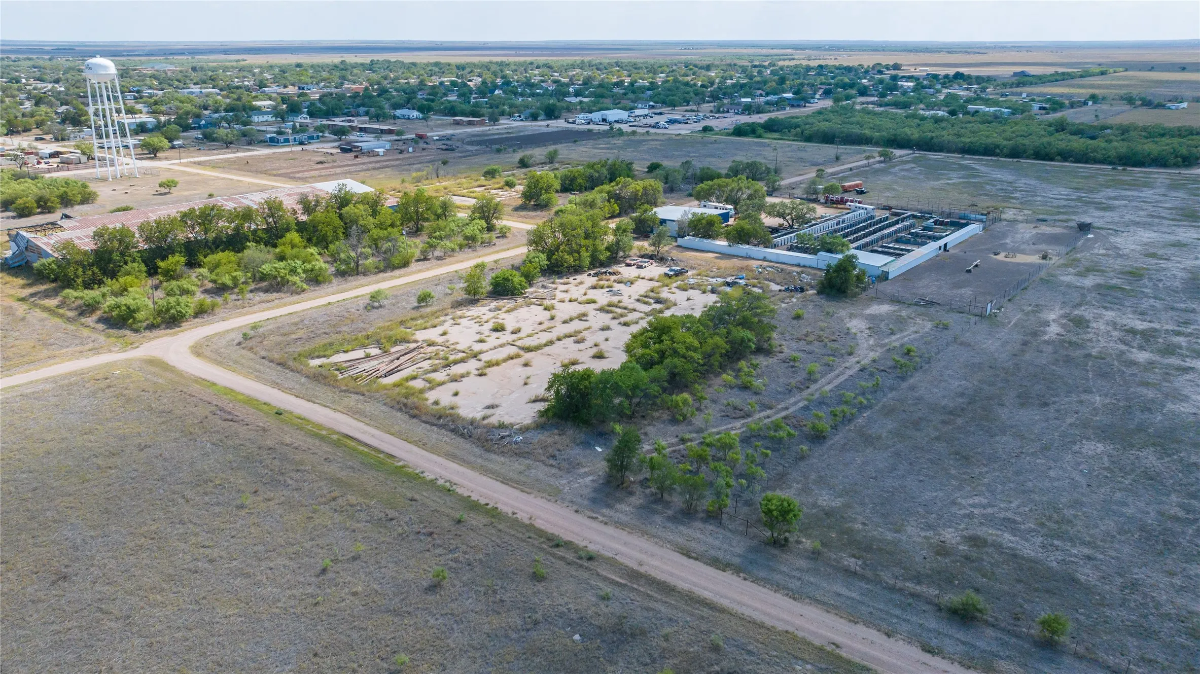 Expansive acreage featuring a water tower, multiple structures, and a network of unpaved roads