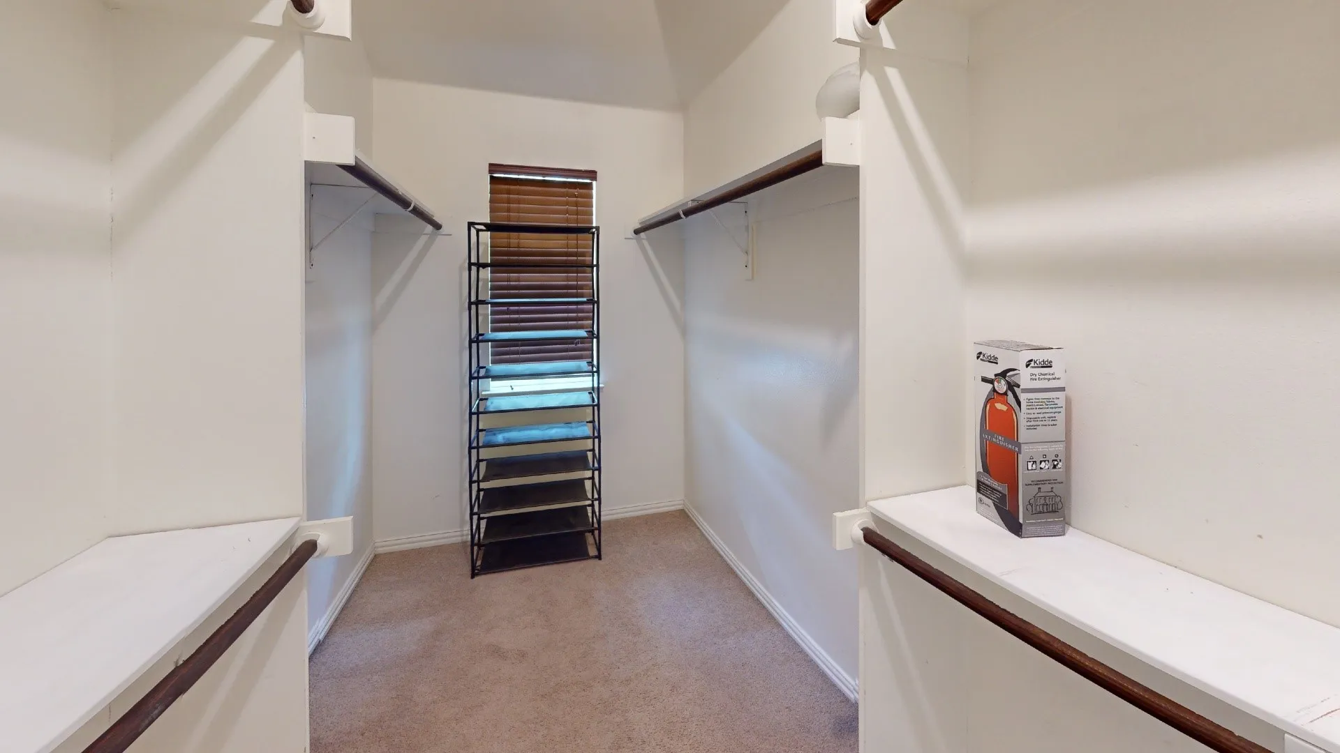 Walk-in closet with carpeted flooring, built-in shelving, and hanging rods
