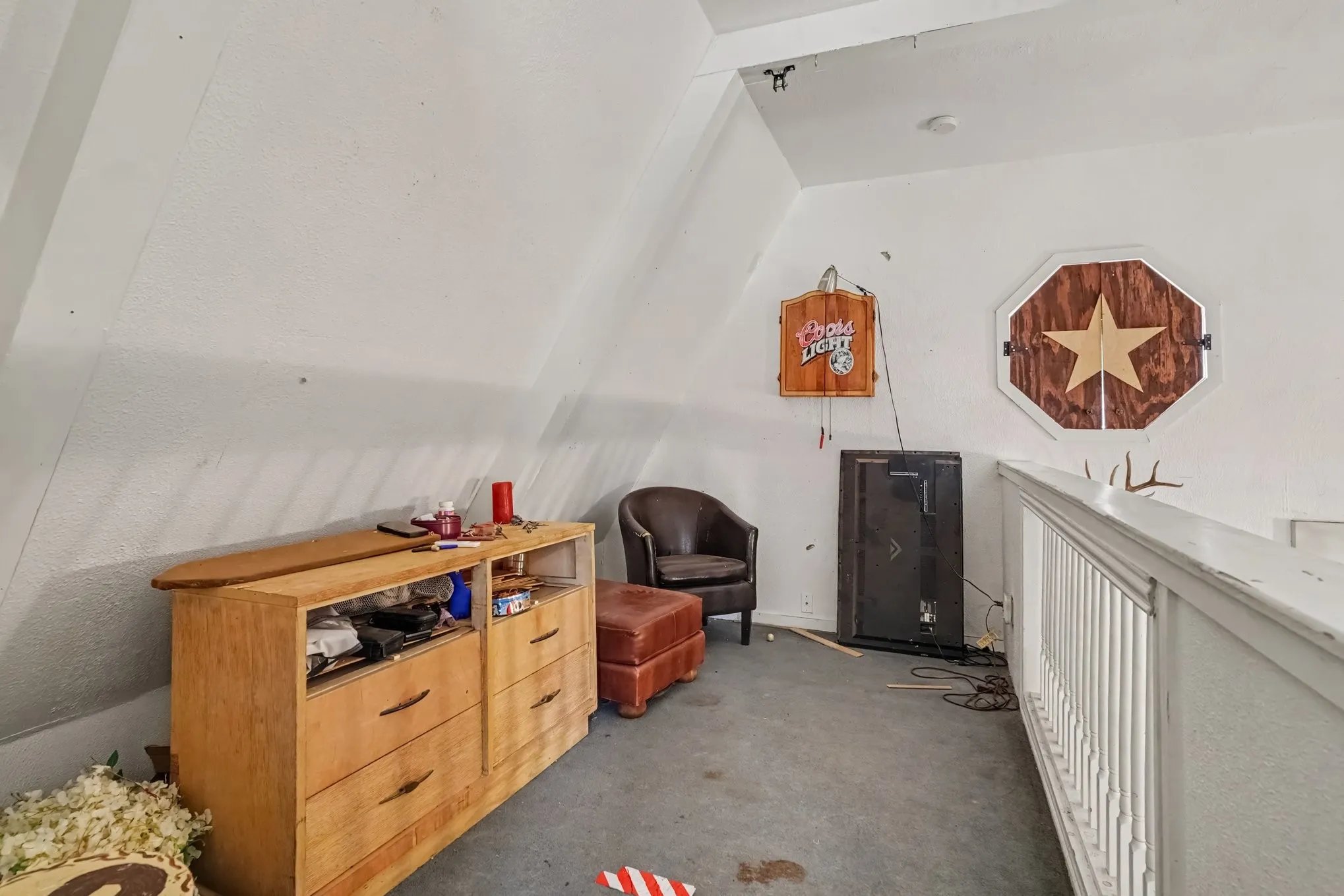 Cozy second-floor loft area tucked under the sloped gambrel ceiling, ideal for a reading nook or media space.