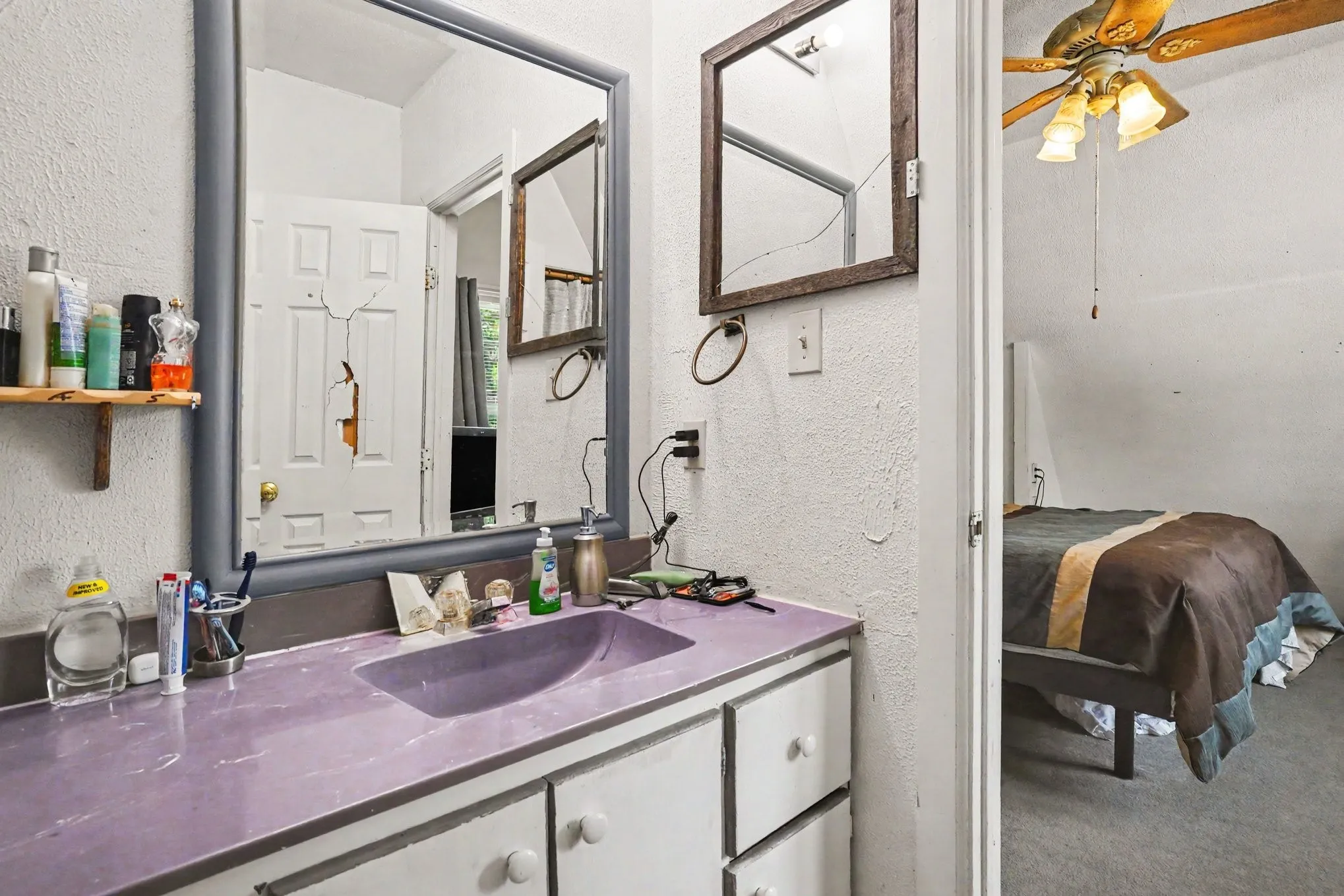 Bathroom alternate view highlighting vanity storage, upper lighting fixtures, and window placement.