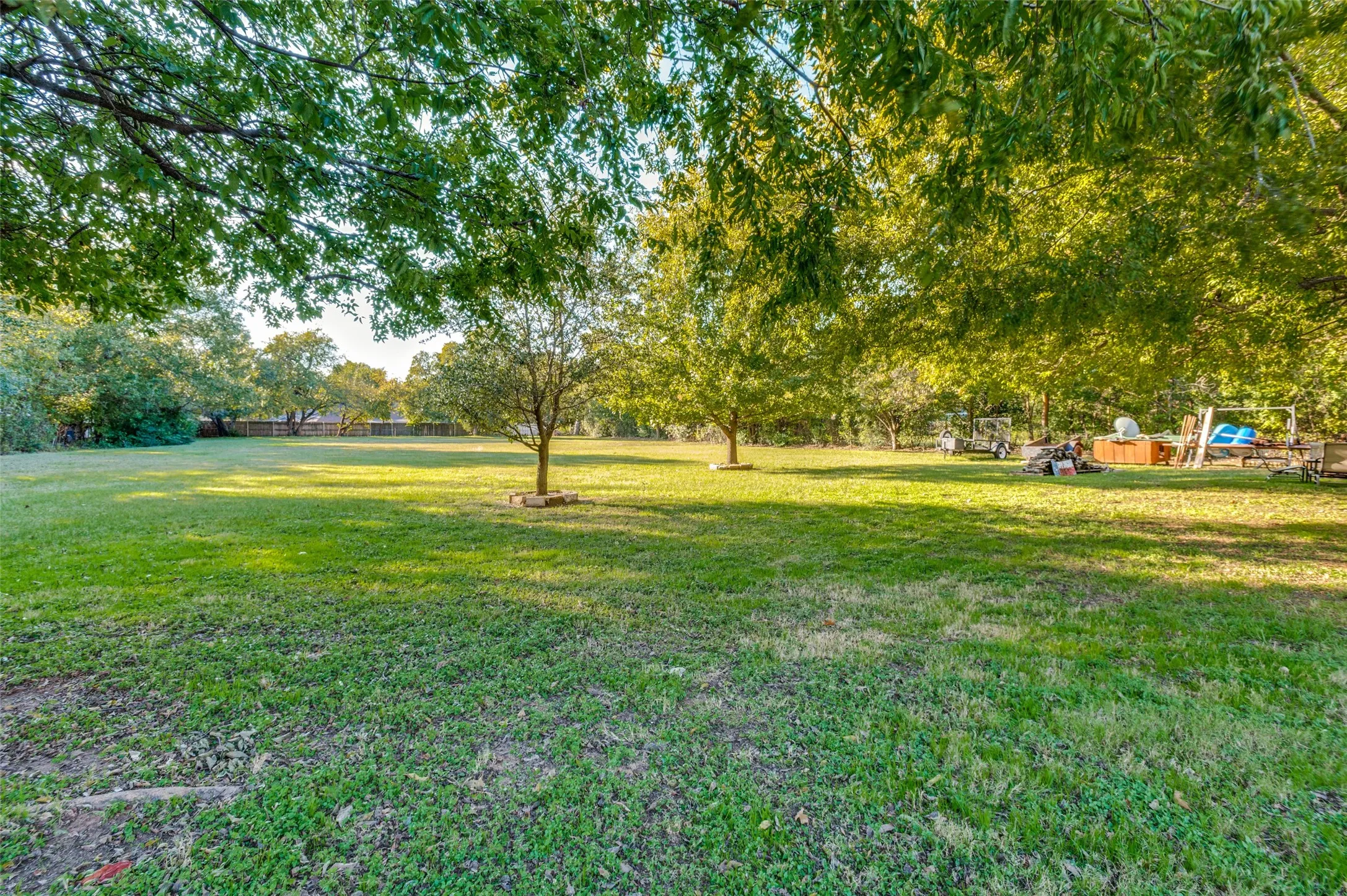Expansive green space featuring mature trees and a manicured lawn