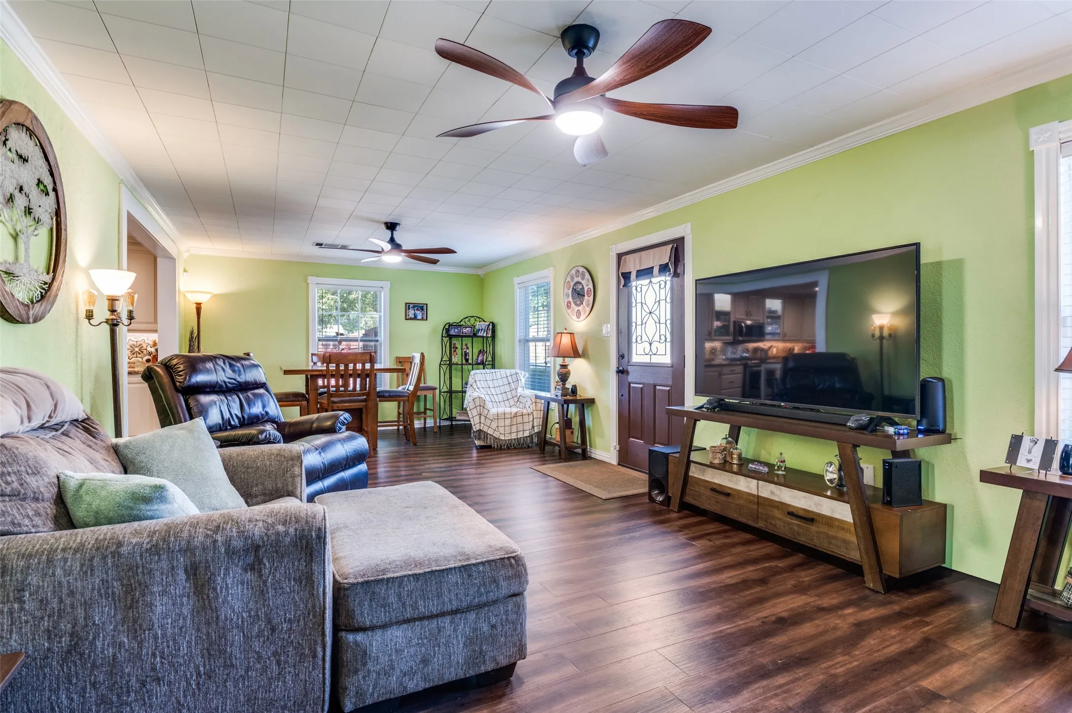 Wood-finish flooring throughout, featuring a paneled ceiling with recessed lighting