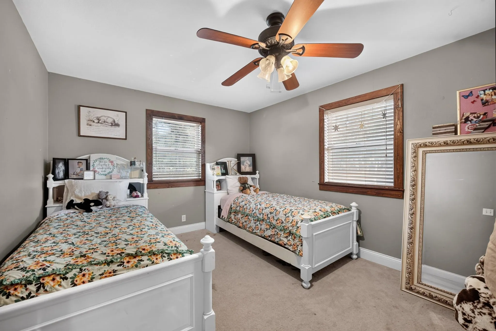 Ceiling fan with light fixture, window with blinds, wood-finish window trim, and wall-to-wall carpeting